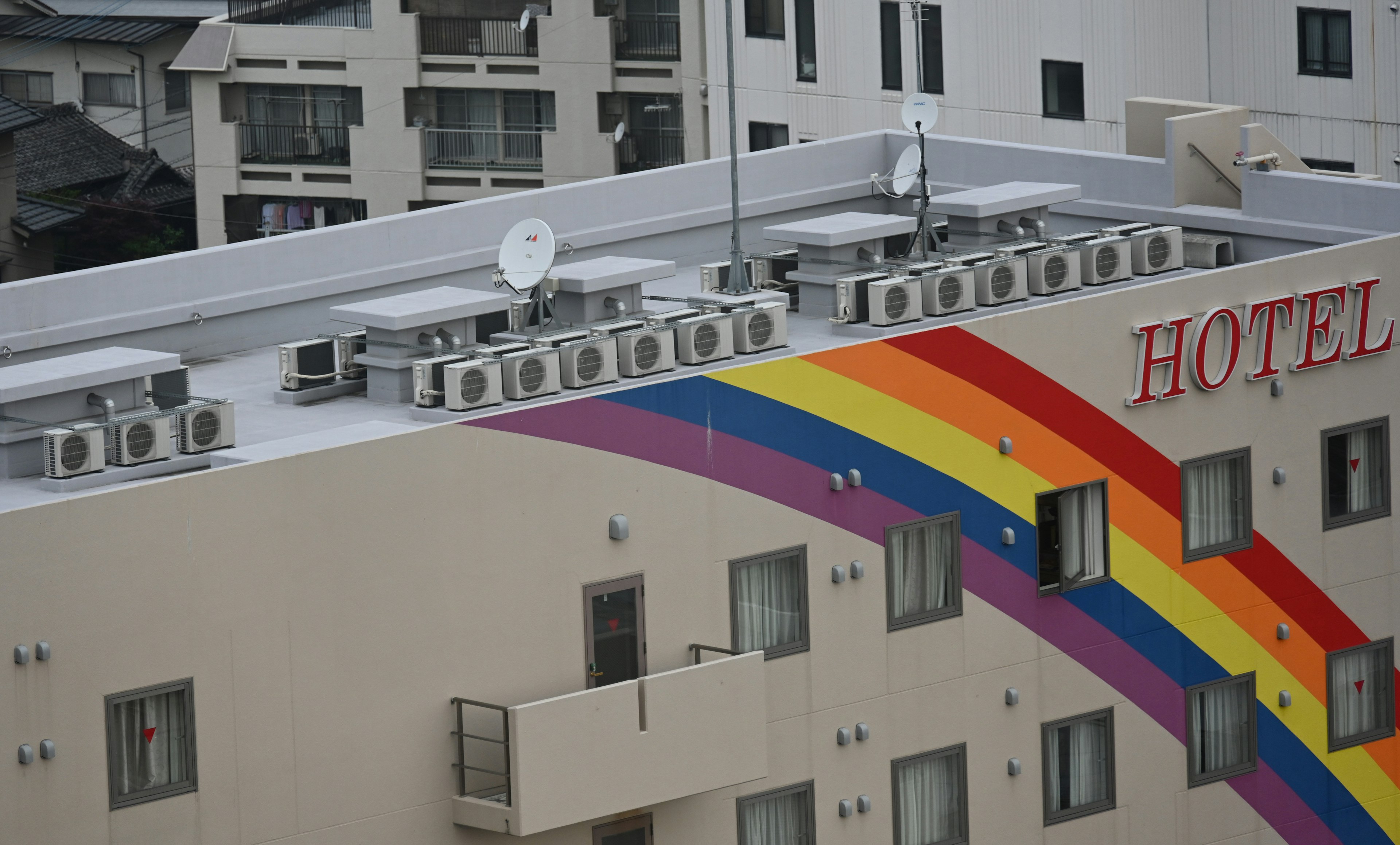 Arte arcobaleno sull'esterno dell'hotel con unità di climatizzazione sul tetto