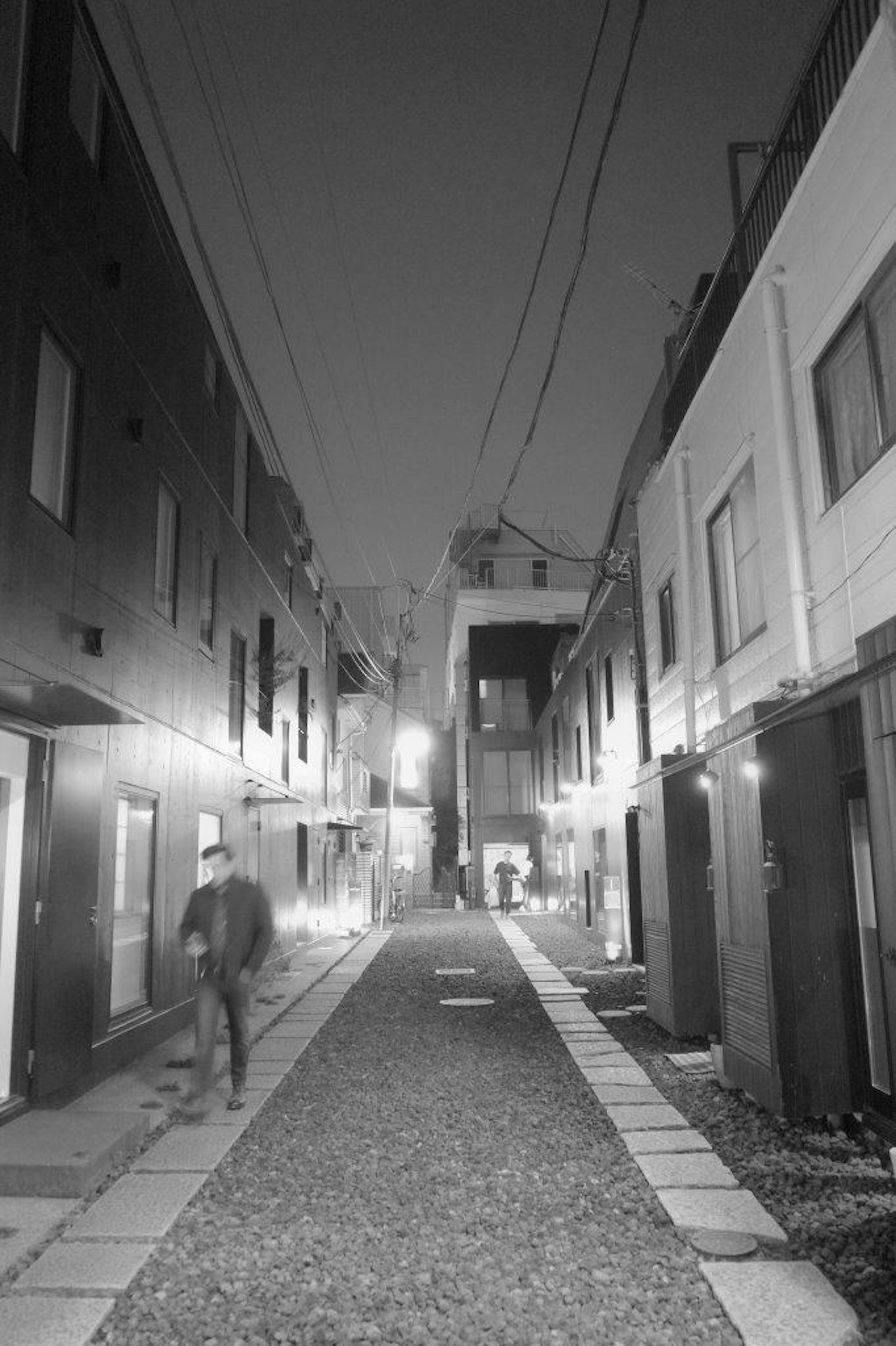 Allée calme de nuit avec des bâtiments en noir et blanc de chaque côté