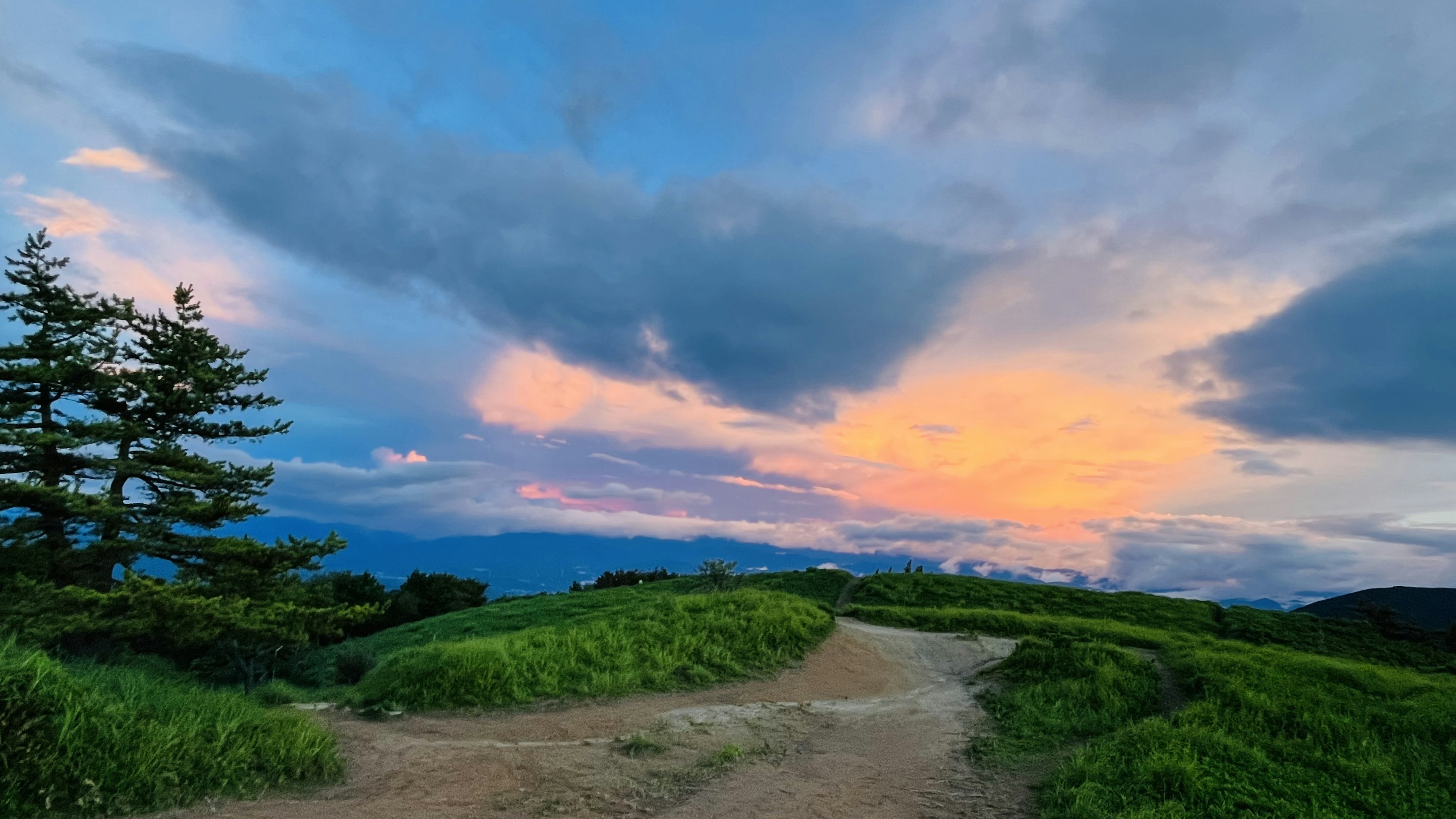 青い空と夕焼けの色合いが美しい風景の道