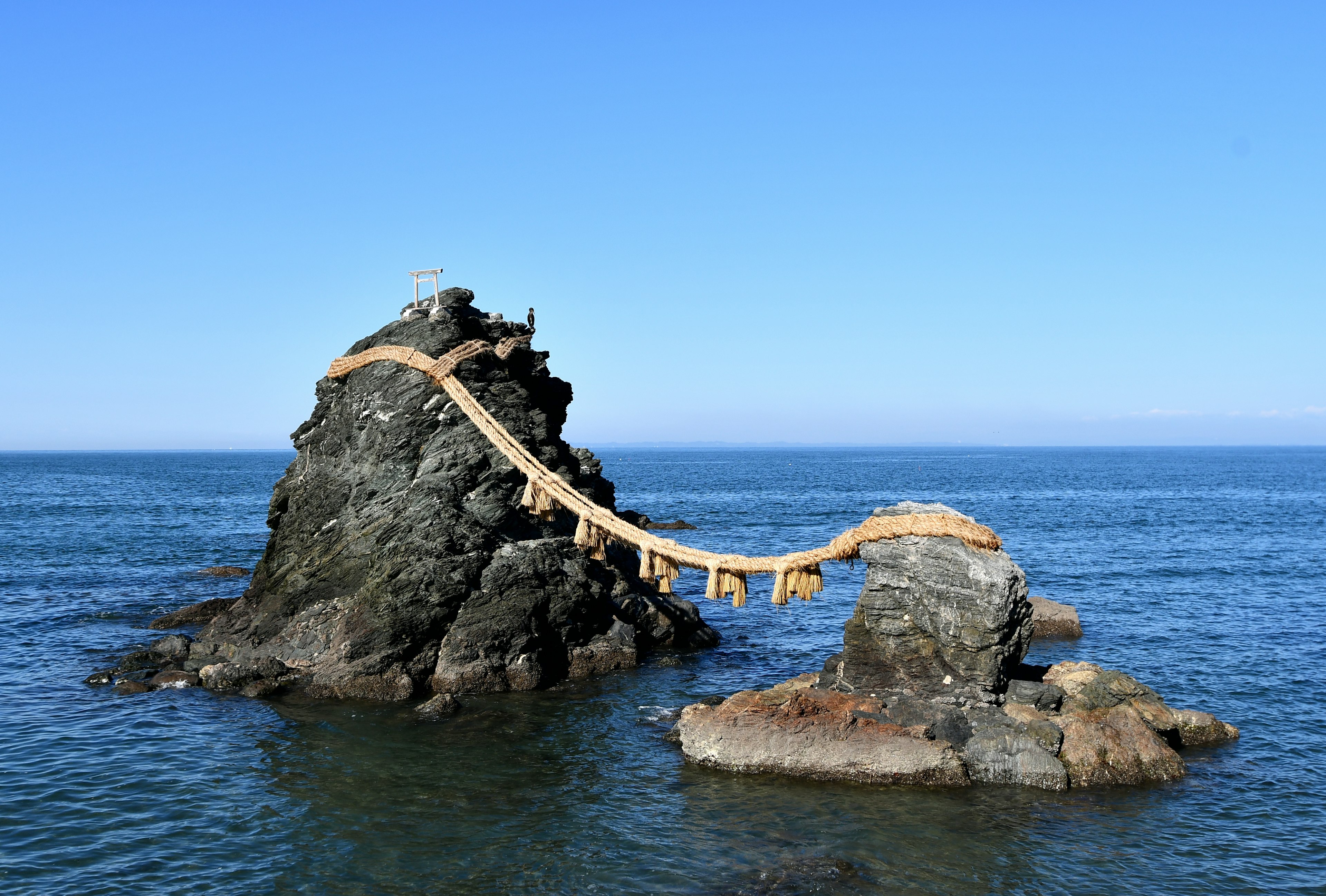 Scenic view of rocks in the ocean with a wooden bridge