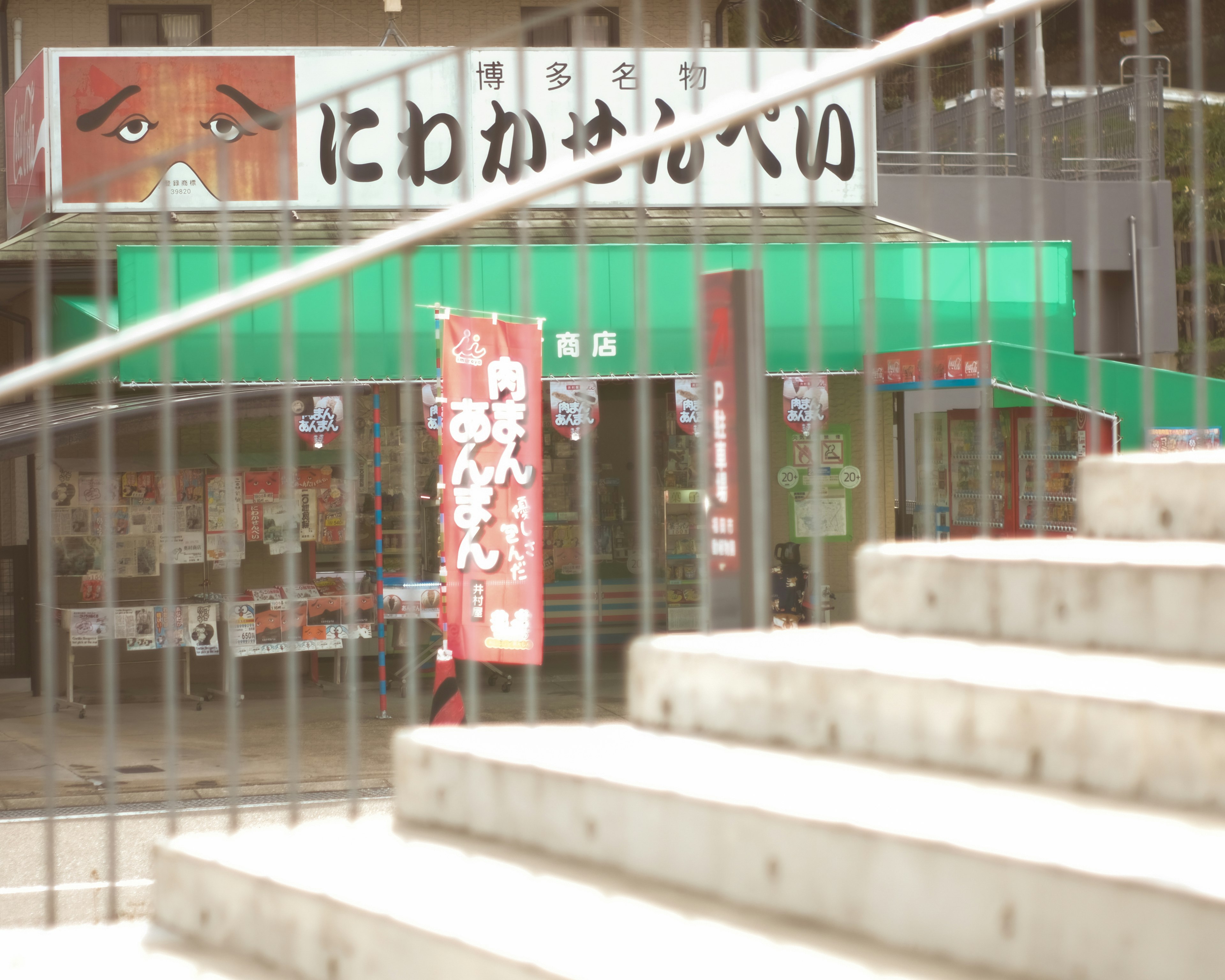 Japanese diner with green exterior featuring a distinctive face on the sign