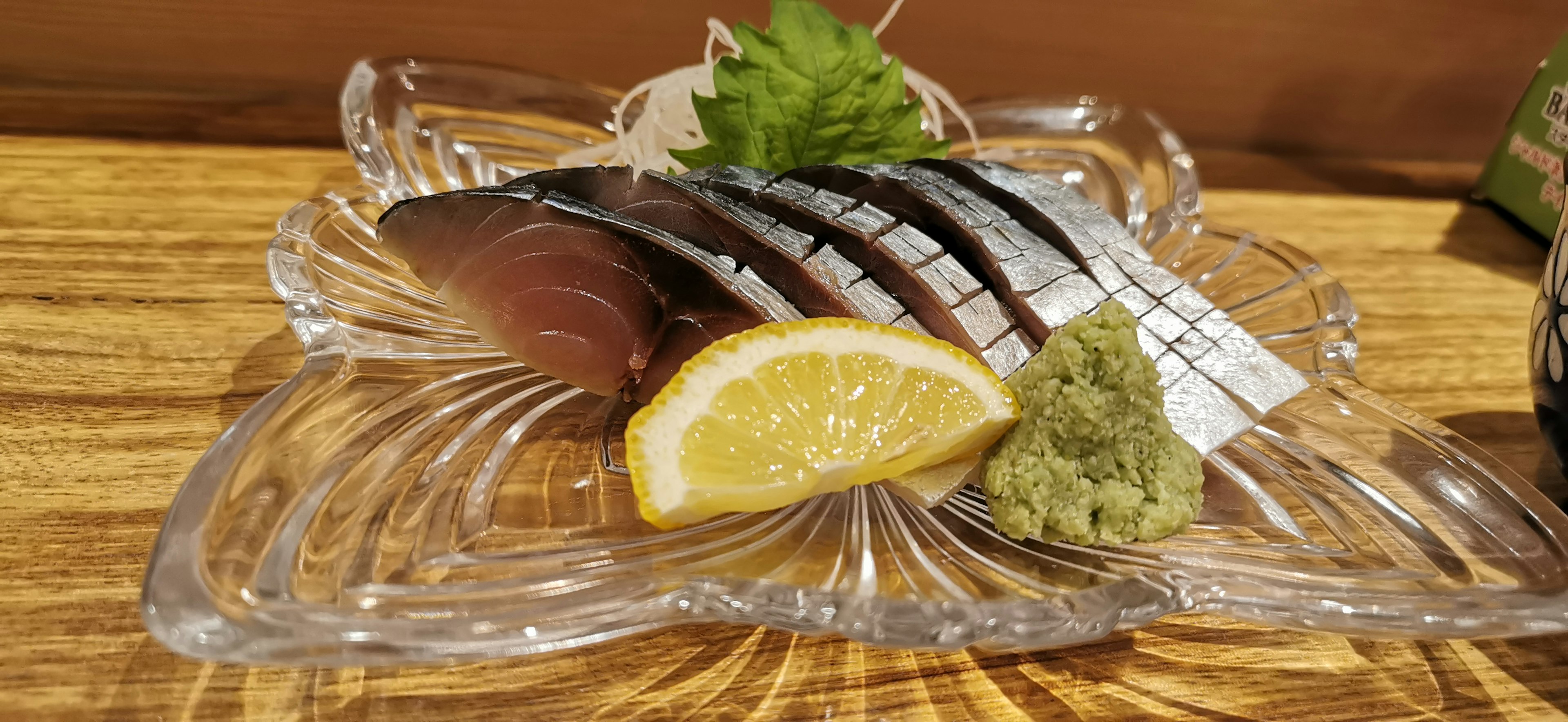 Fresh sashimi arranged on a plate with lemon and wasabi