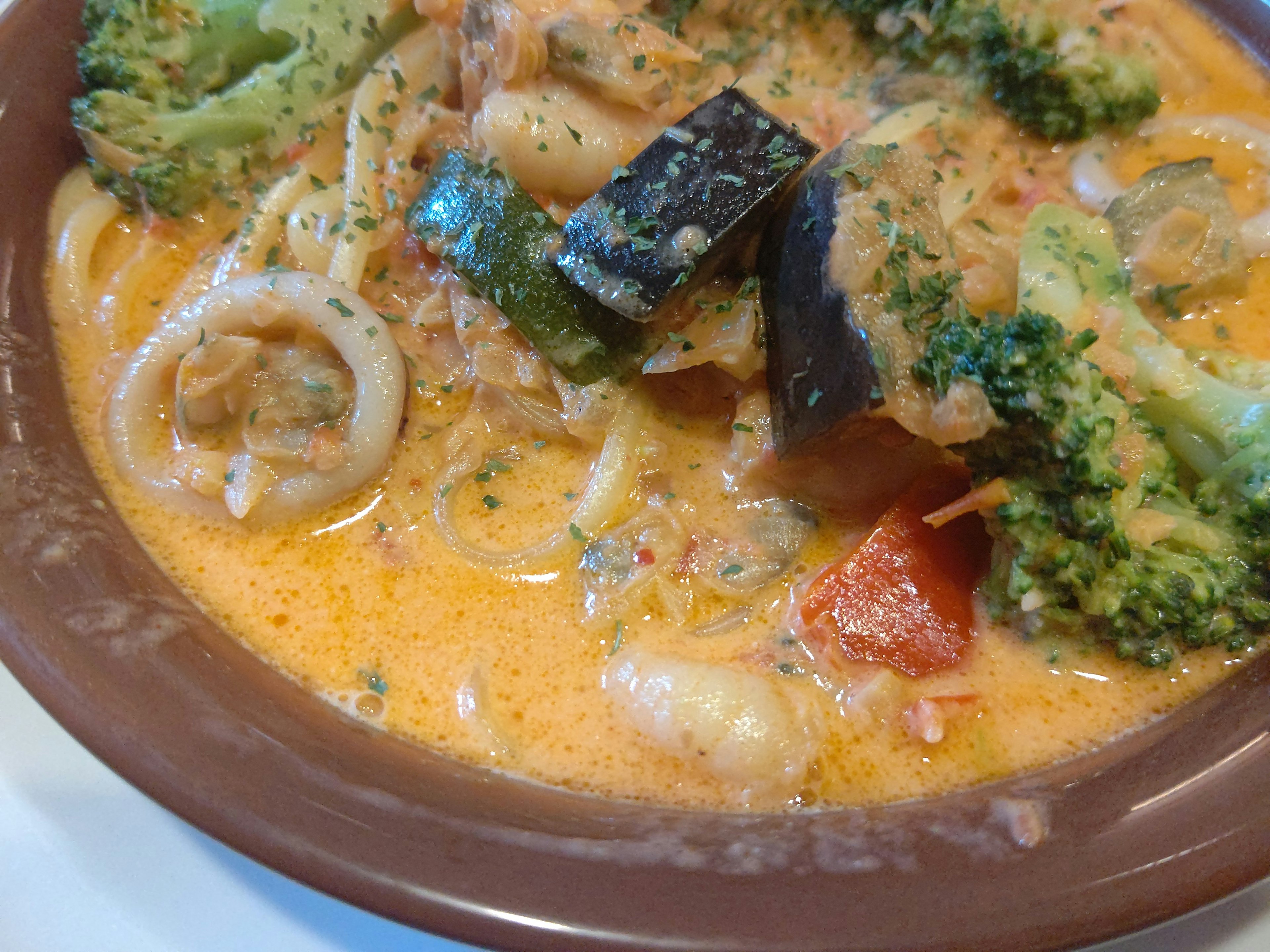 Piatto di zuppa cremosa con frutti di mare e verdure