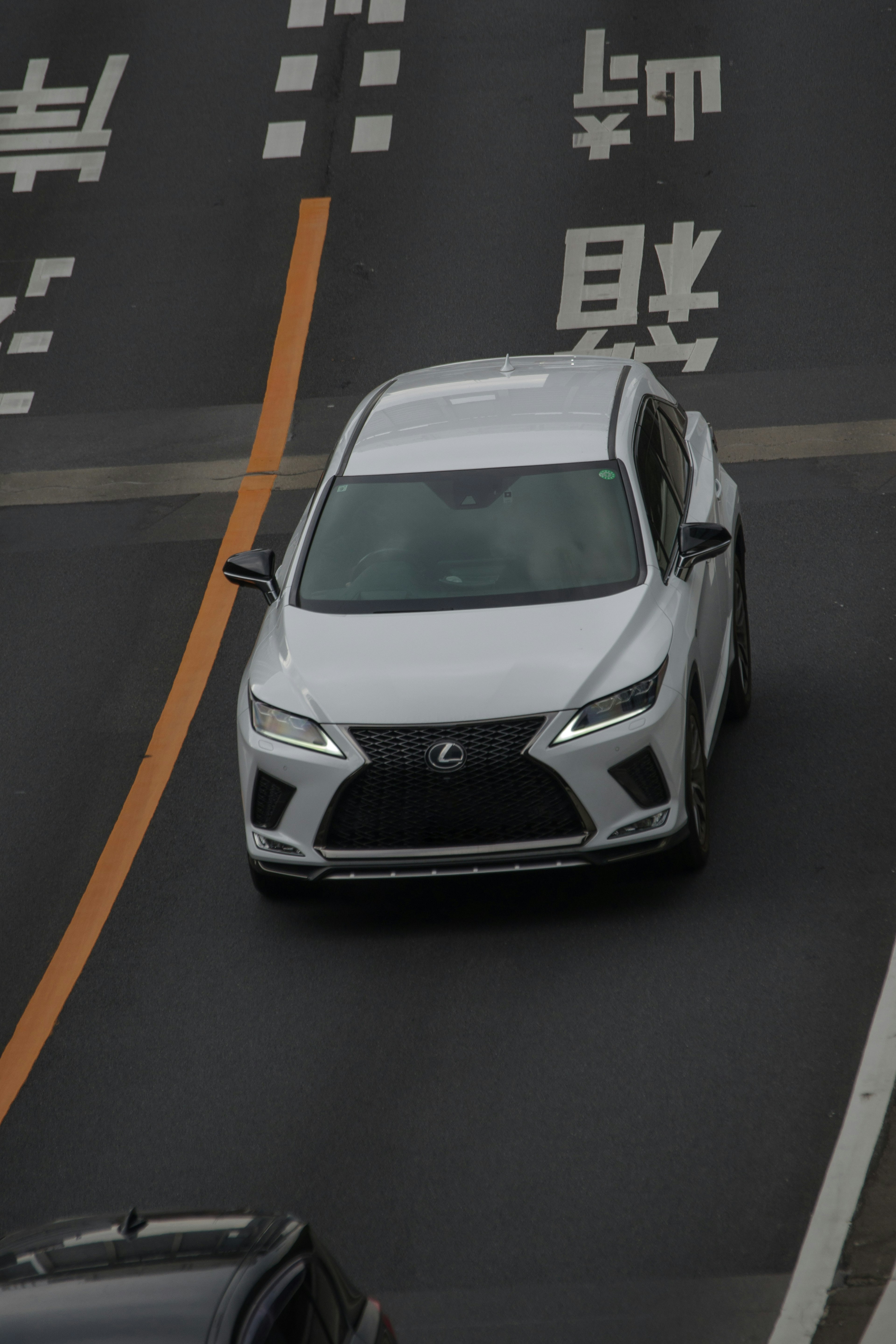 White Lexus SUV driving on the road