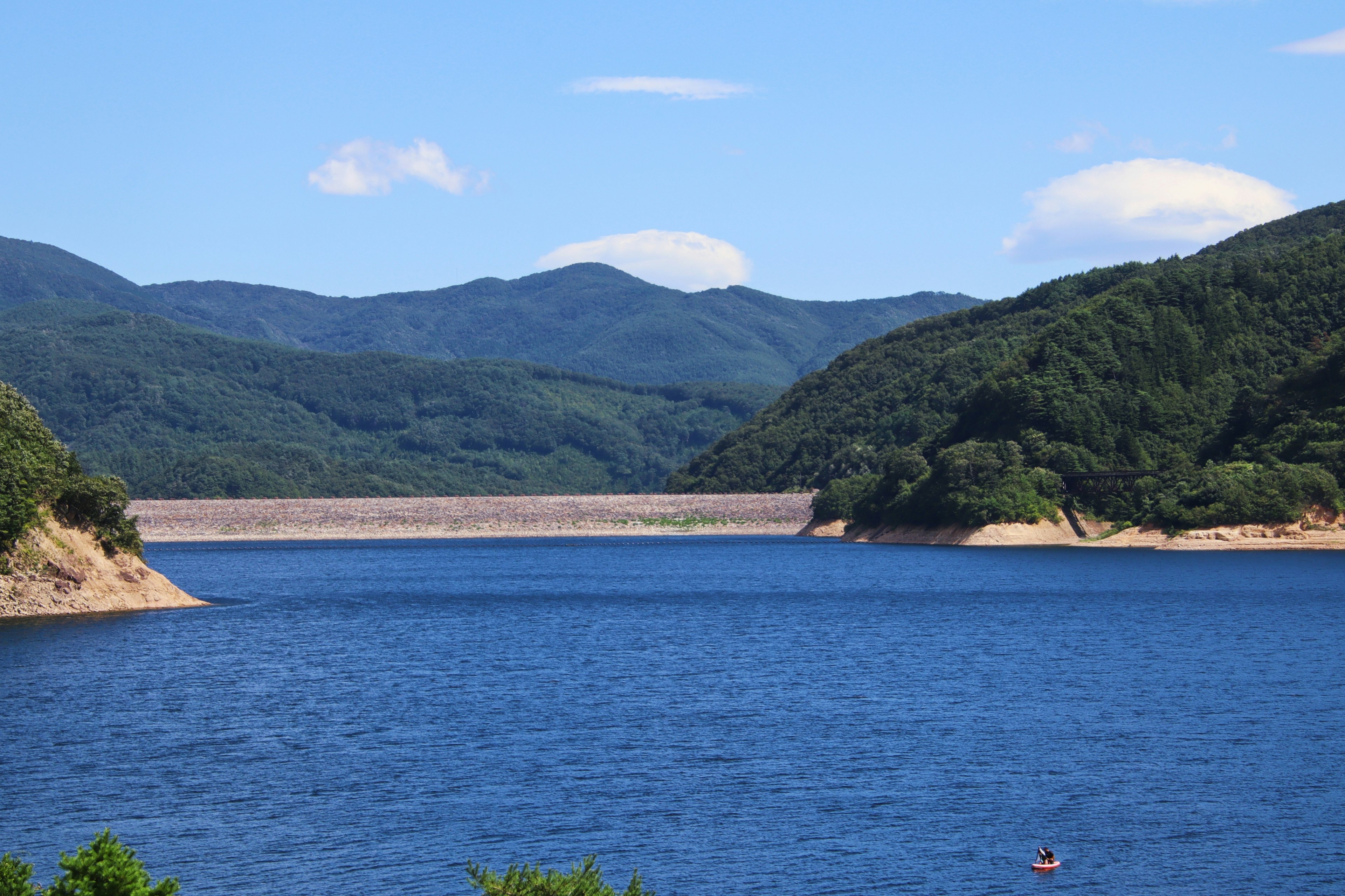 Landschaft mit einem blauen See und grünen Bergen