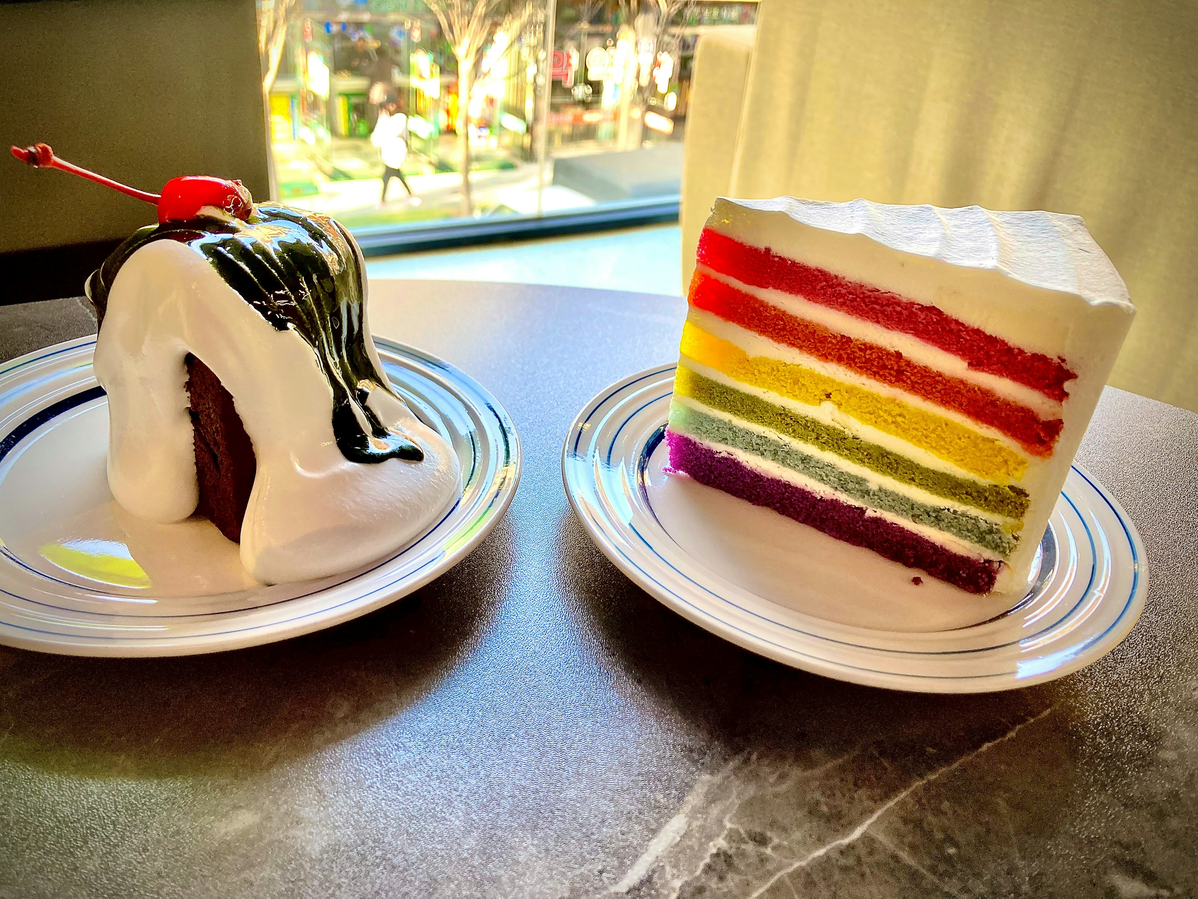 Colorful layered rainbow cake and dessert with chocolate sauce