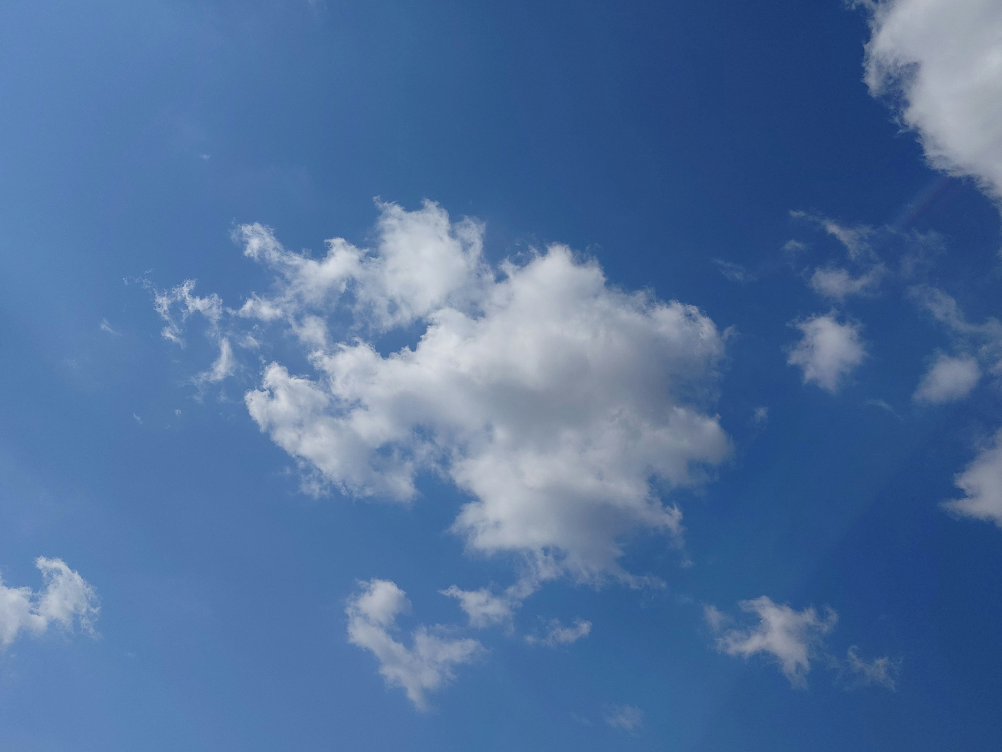 Eine Ansicht von weißen Wolken, die in einem blauen Himmel schweben