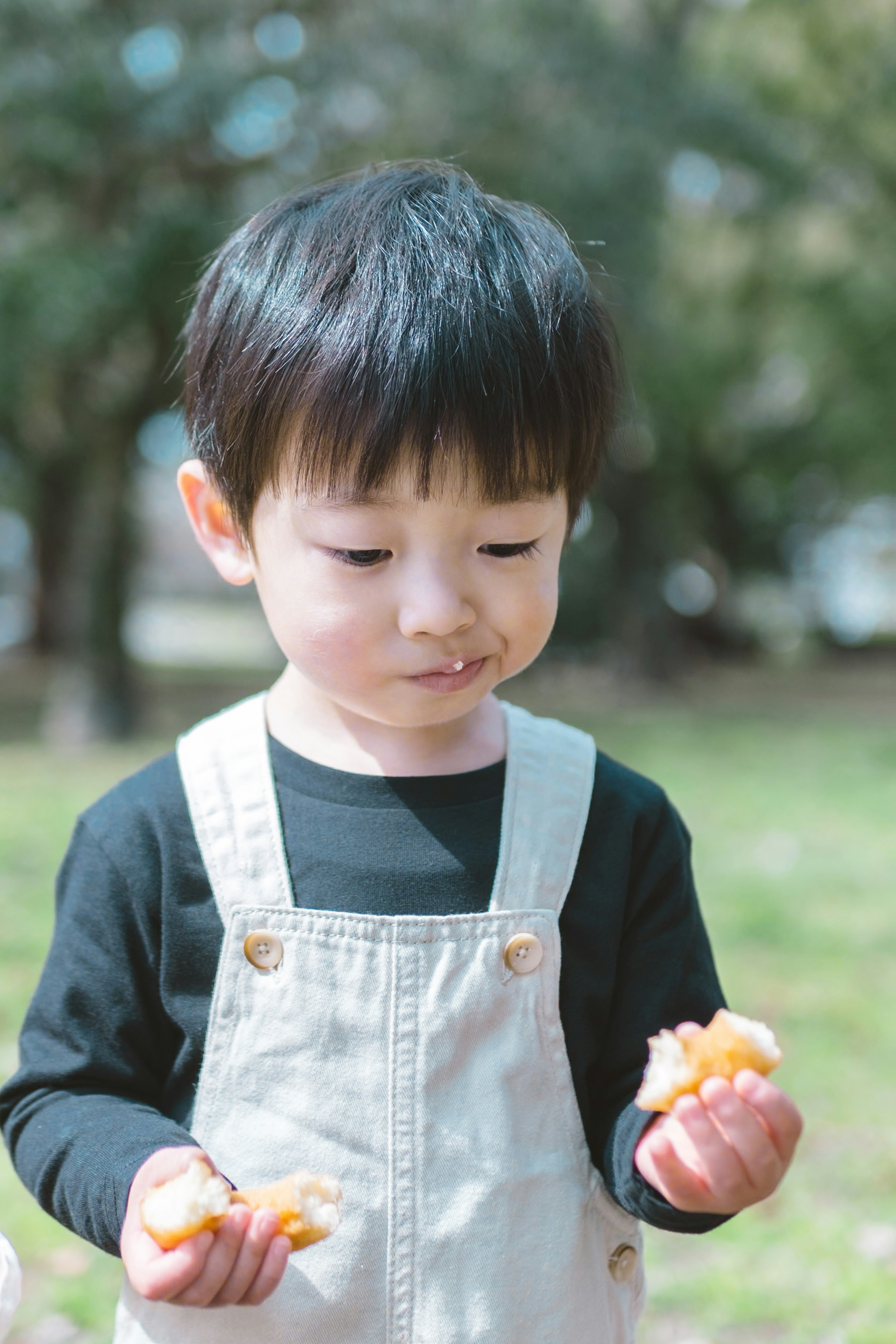 公園で食べ物を持っている小さな子供