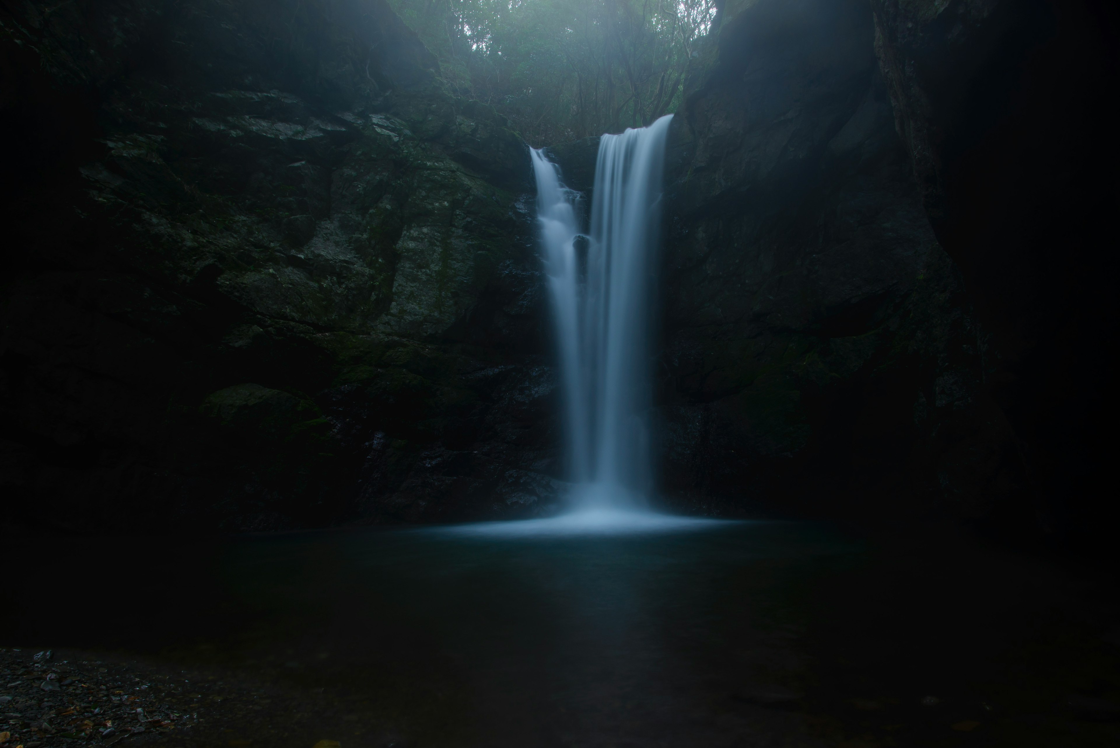 Ein schöner Wasserfall, der in einer schwach beleuchteten Umgebung fließt