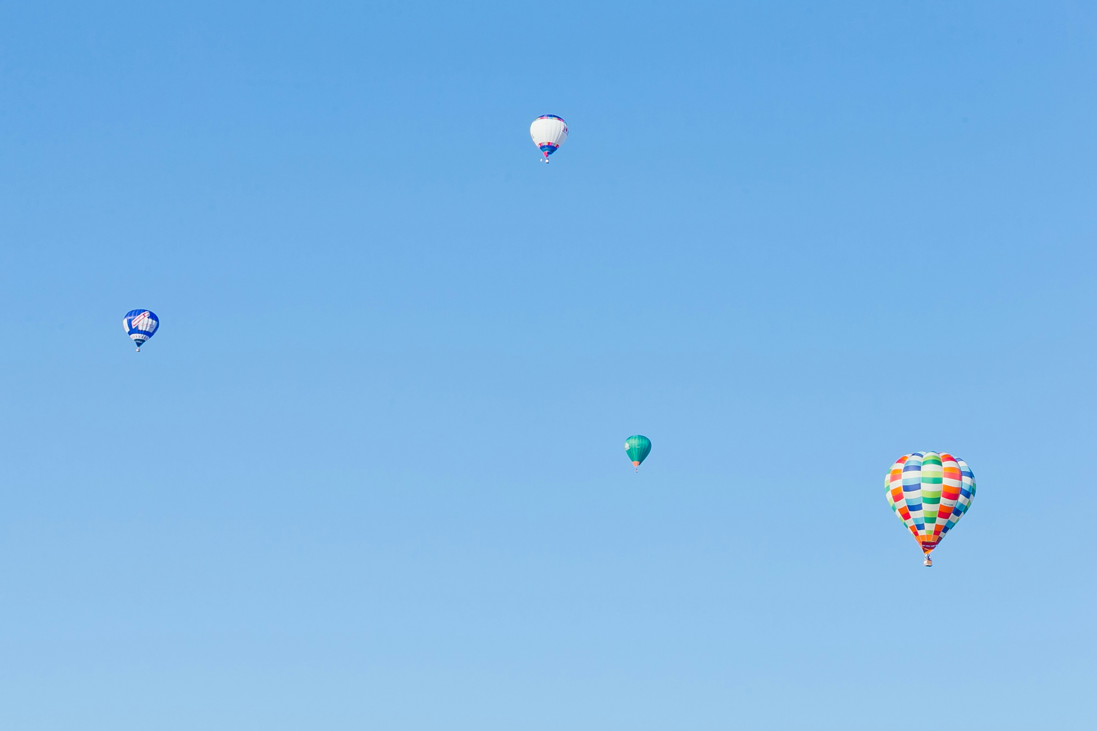 Ballons à air chaud colorés flottant dans un ciel bleu clair