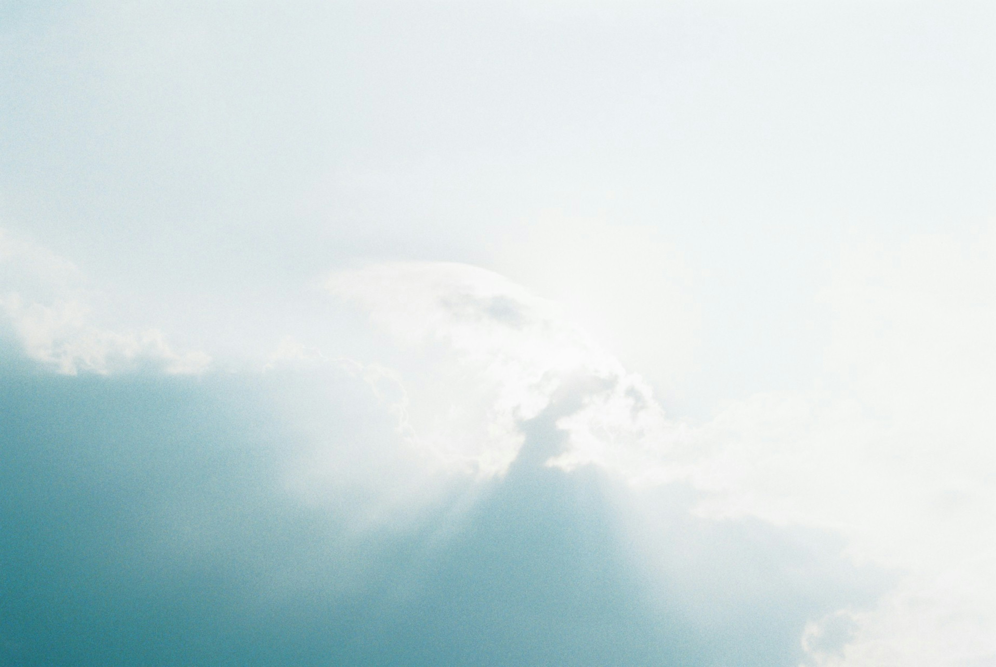 Sanfter blauer Himmel mit Wolken und Lichteffekten