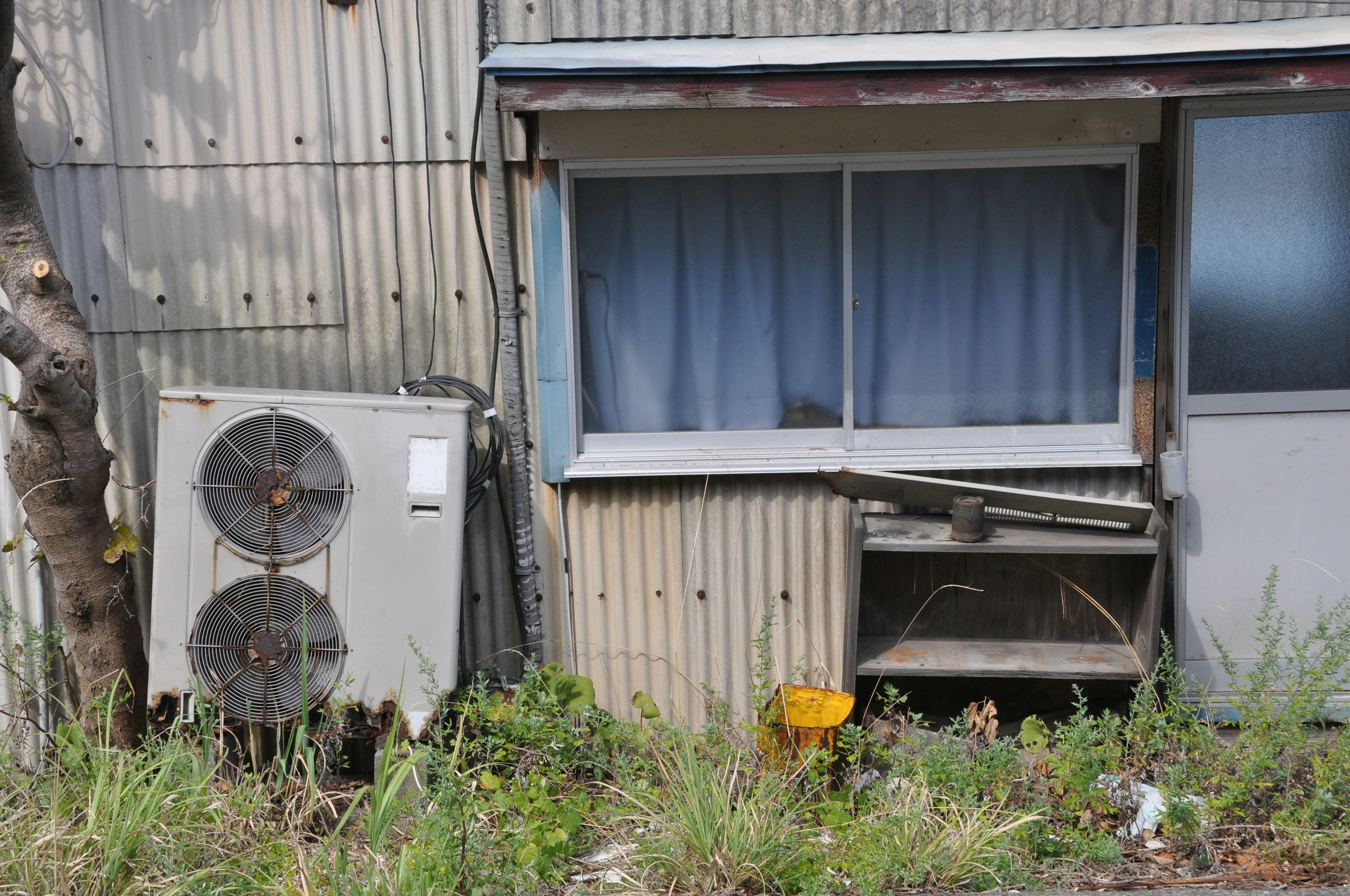 Eine Szene mit einem Fenster und einer Klimaanlage an einem alten Metallgebäude