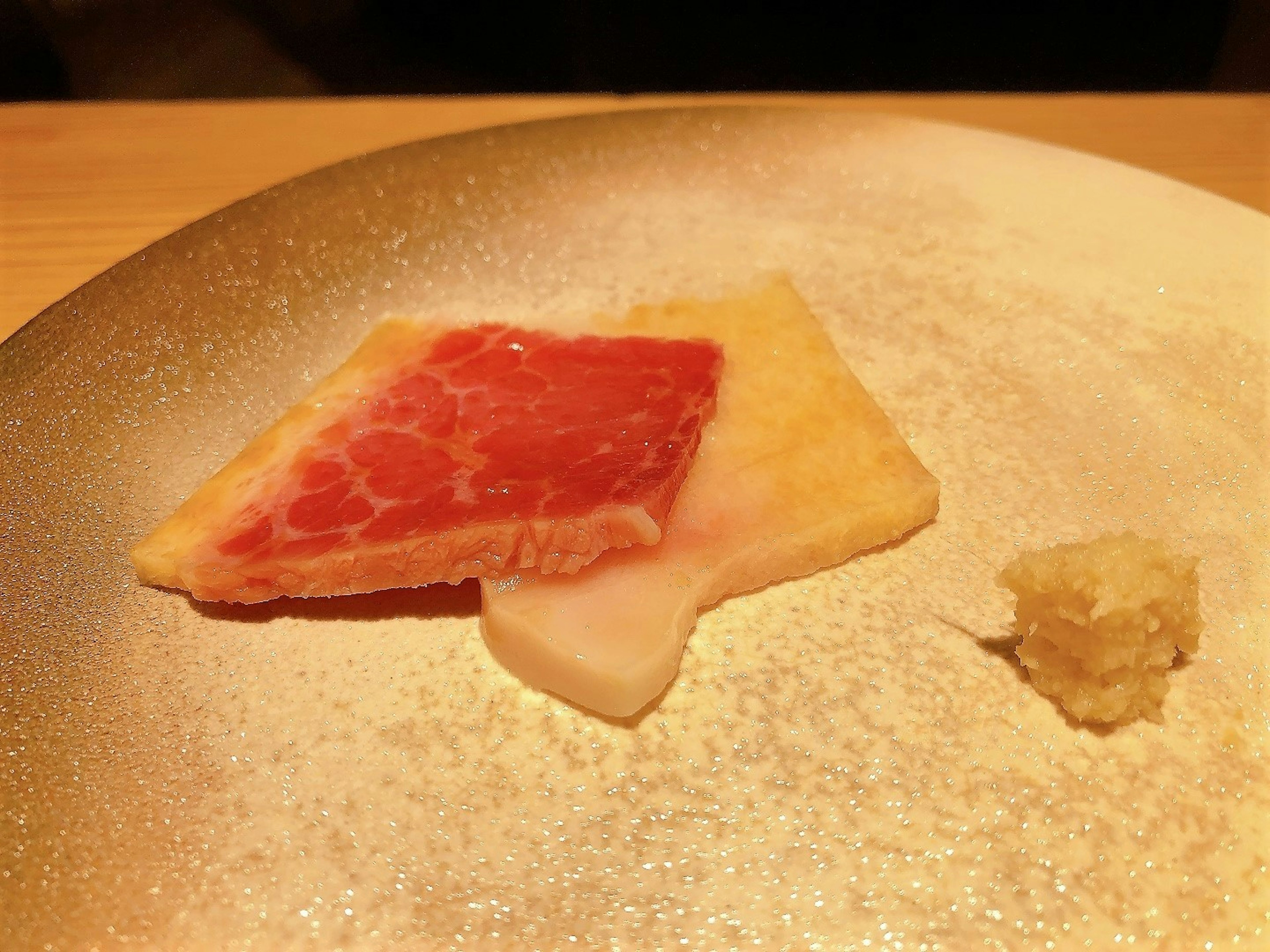 Presentación de carne y wasabi en un plato blanco