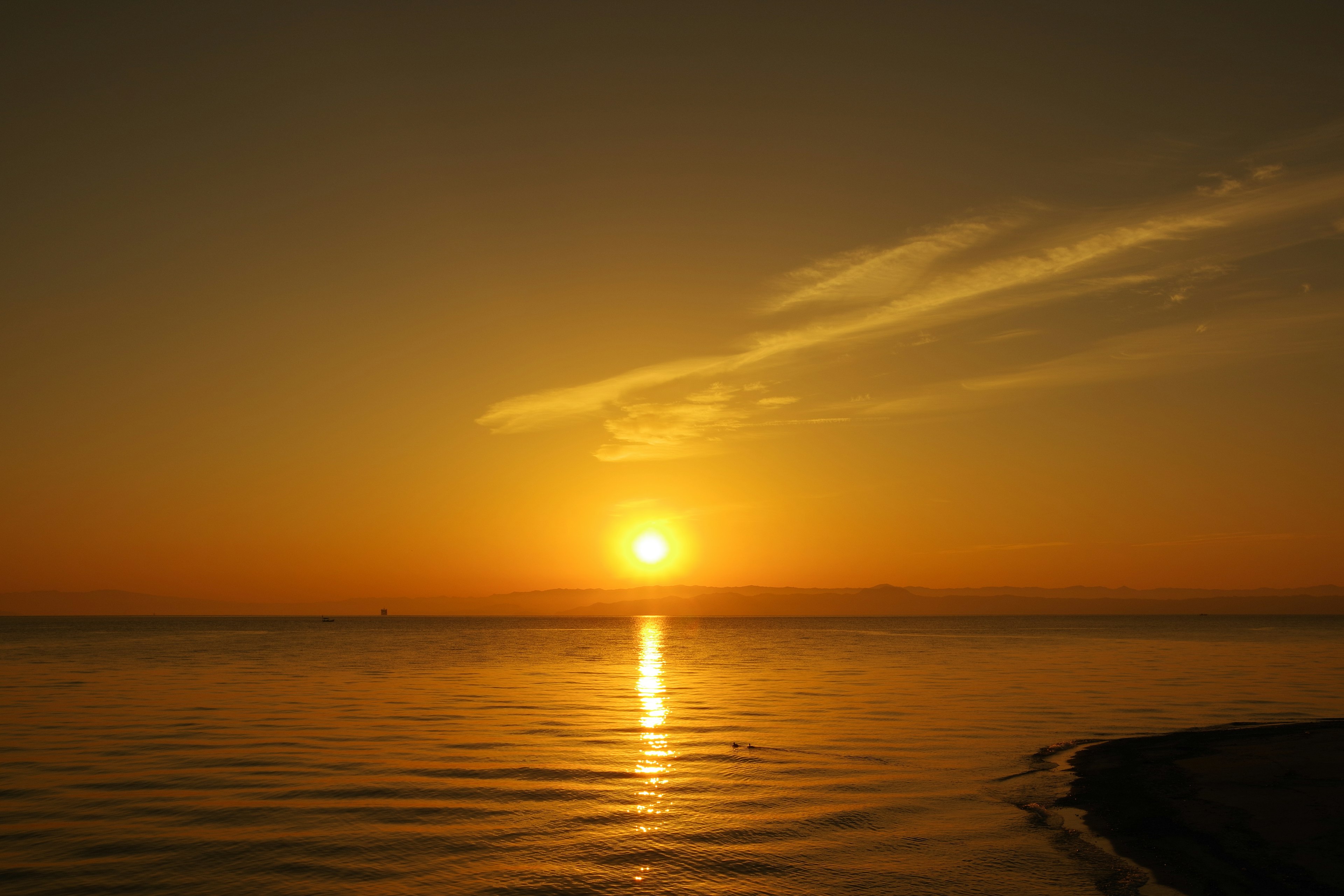 Magnifique coucher de soleil sur la mer calme avec ciel orange et vagues douces