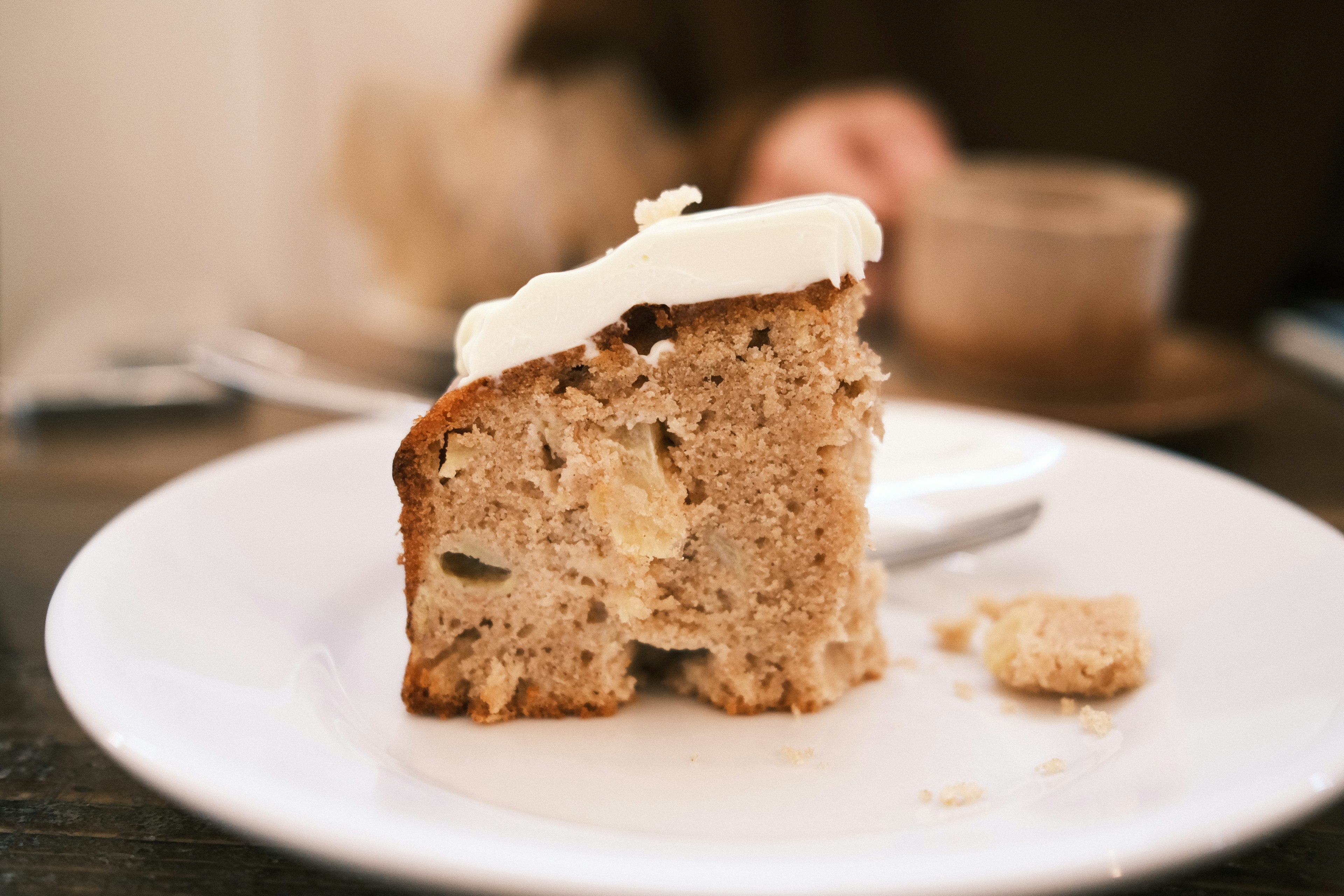 Ein Stück Kuchen mit Sahne auf einem weißen Teller