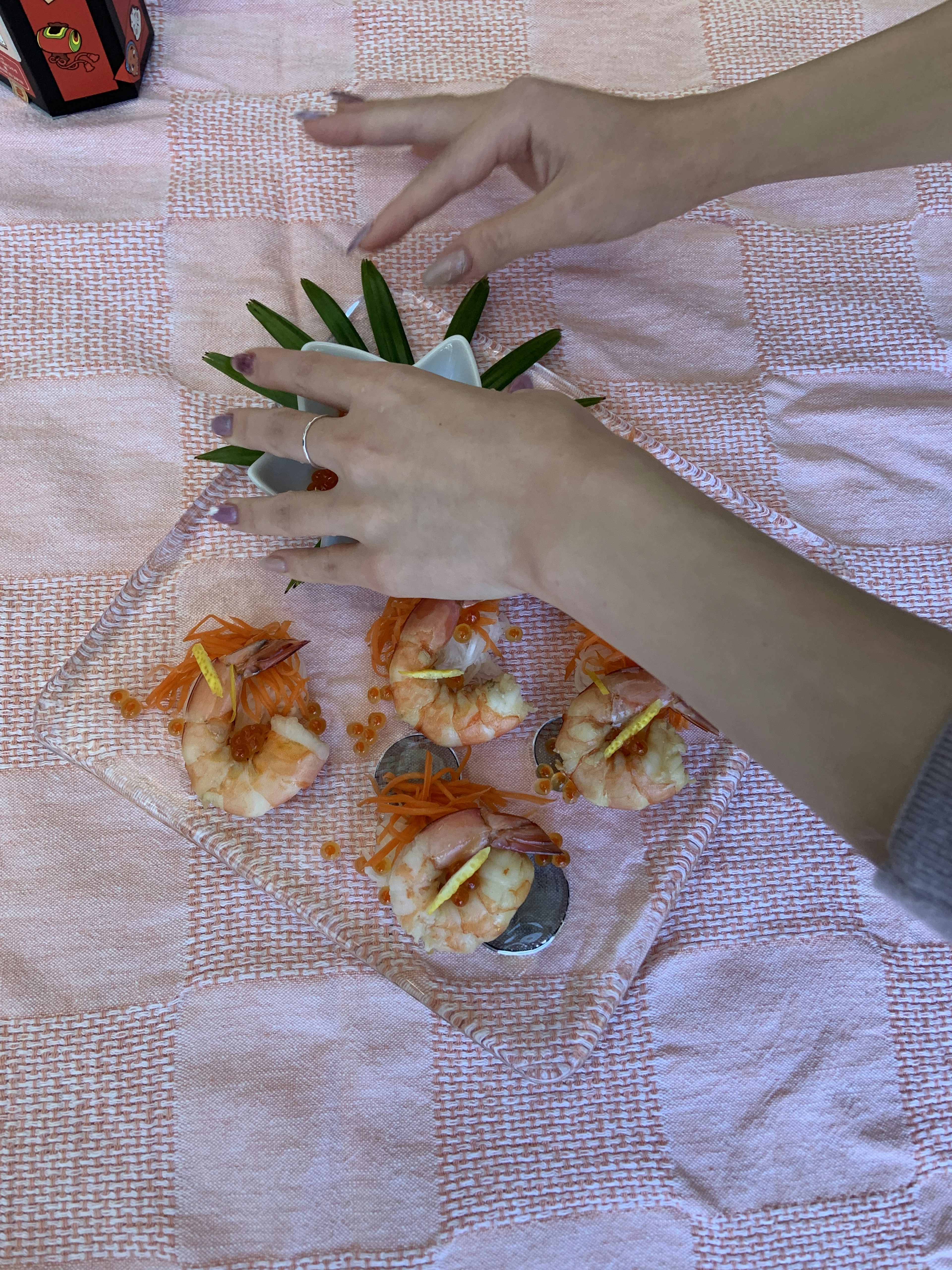 Hands arranging sushi on a pineapple with vibrant colors