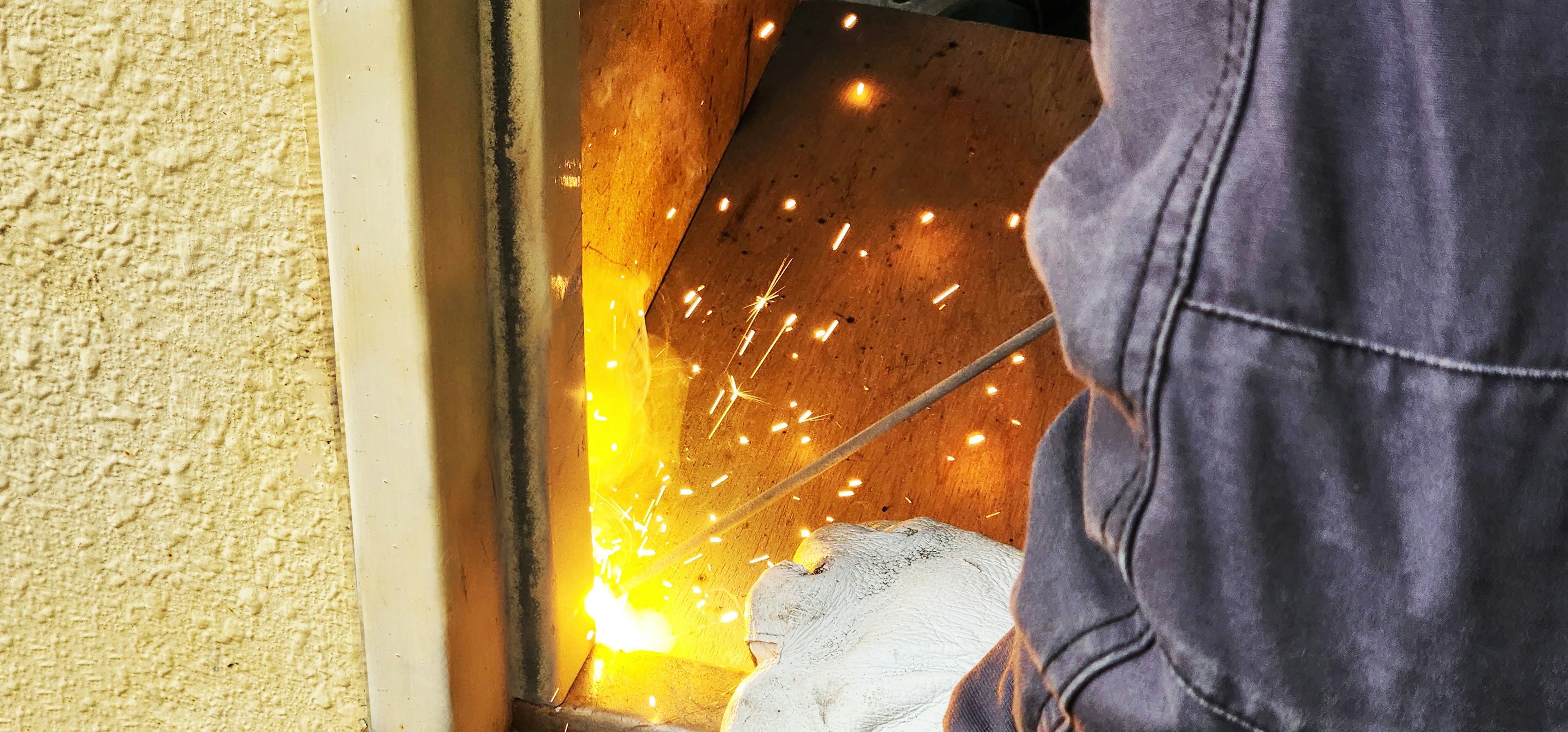 Worker cutting metal with sparks flying from the process