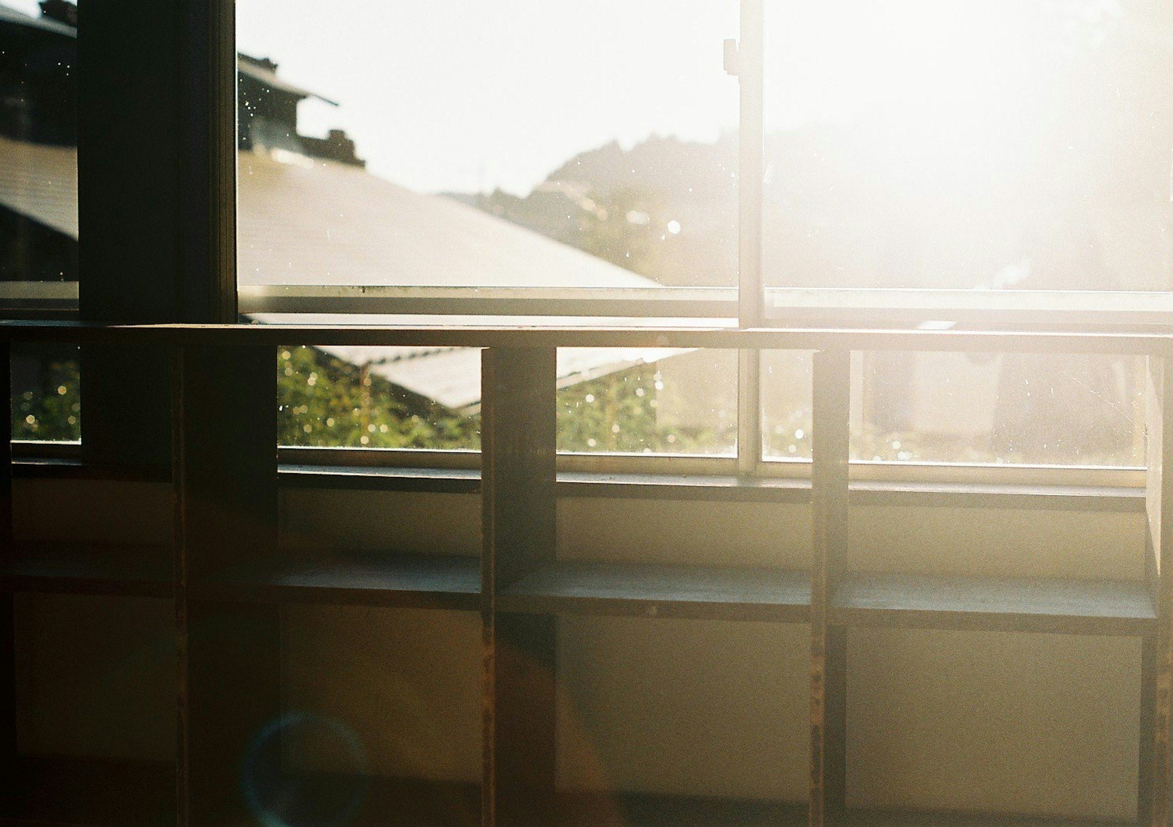 Una foto de estanterías junto a una ventana con luz brillante que entra