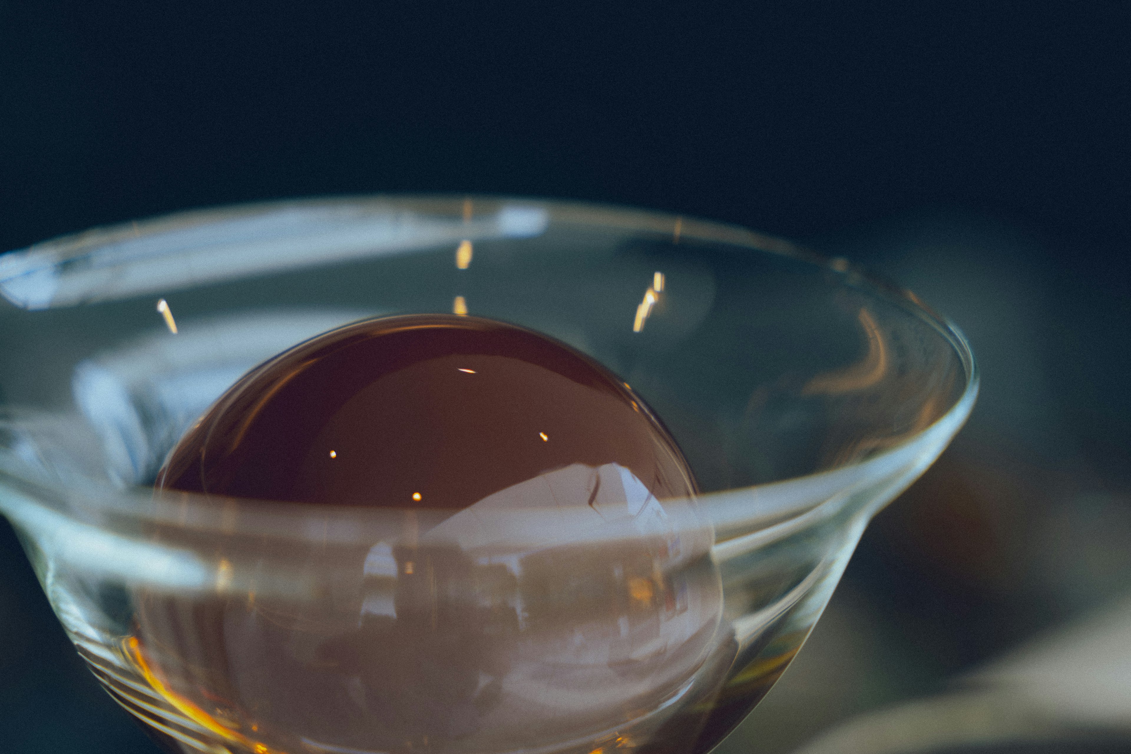 Glossy brown sphere in a transparent glass