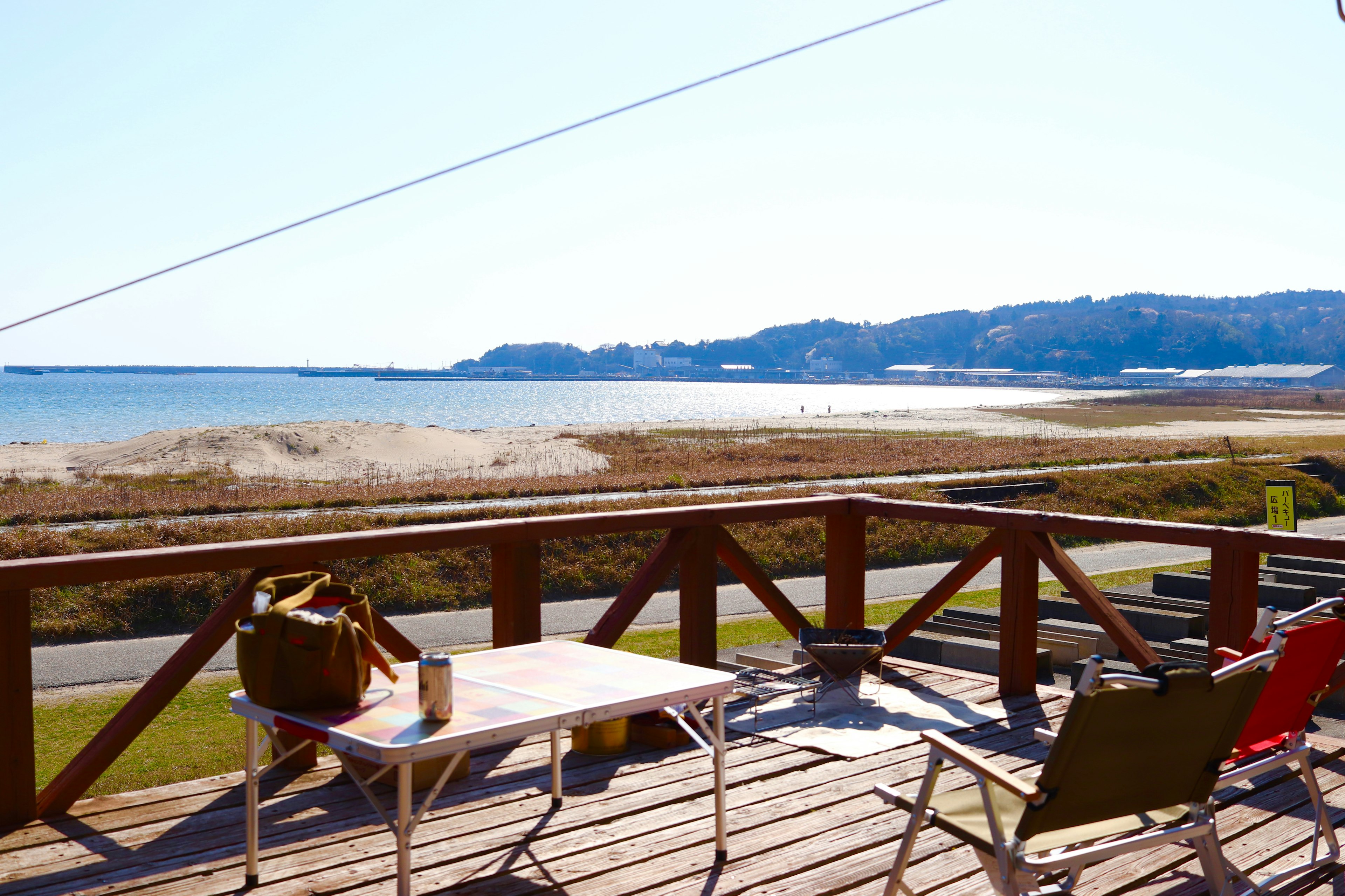 Terrasse surplombant la côte avec des chaises et un sac