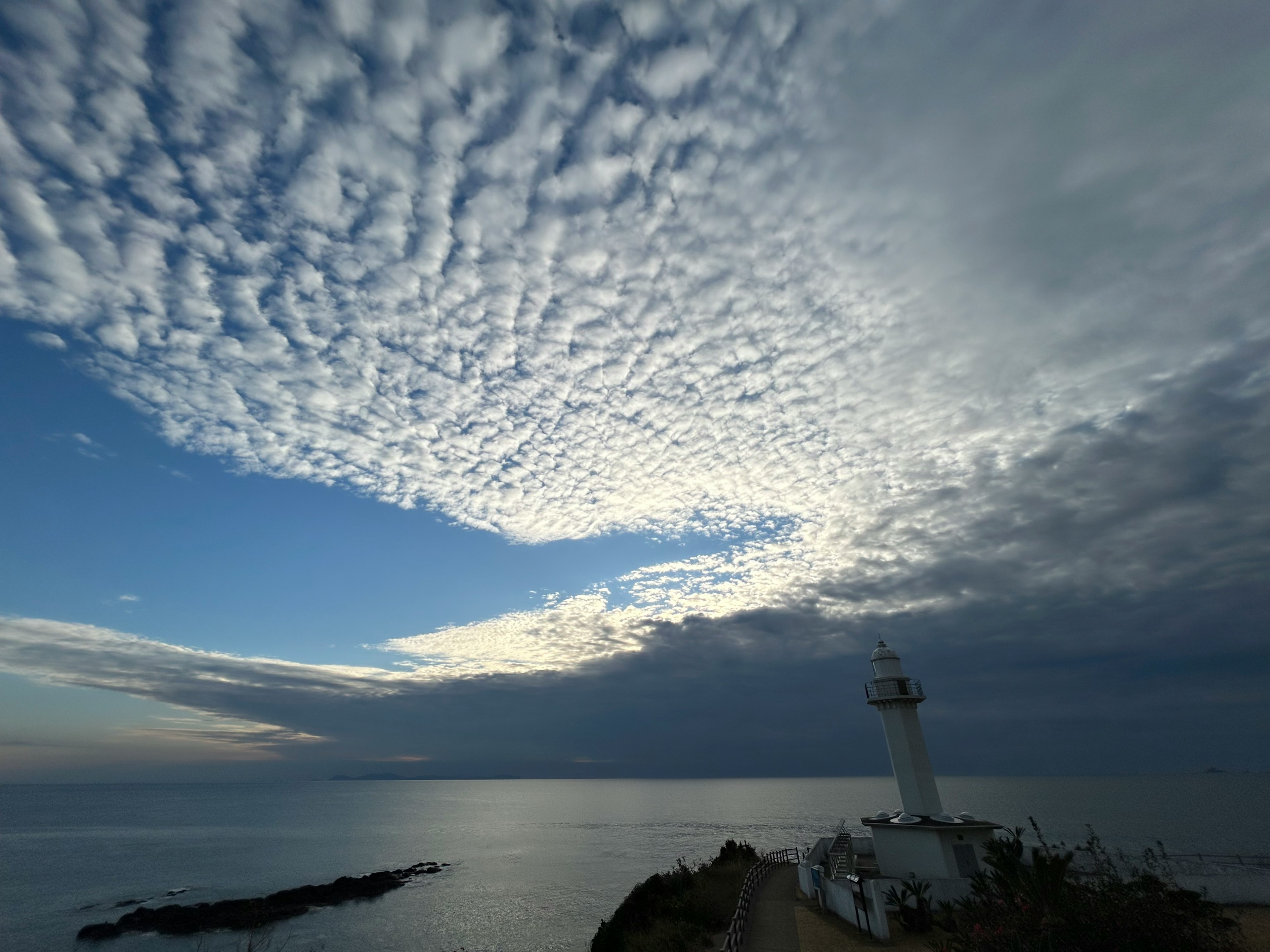 Malersicher Blick auf einen Leuchtturm am Meer unter einem dramatischen Himmel