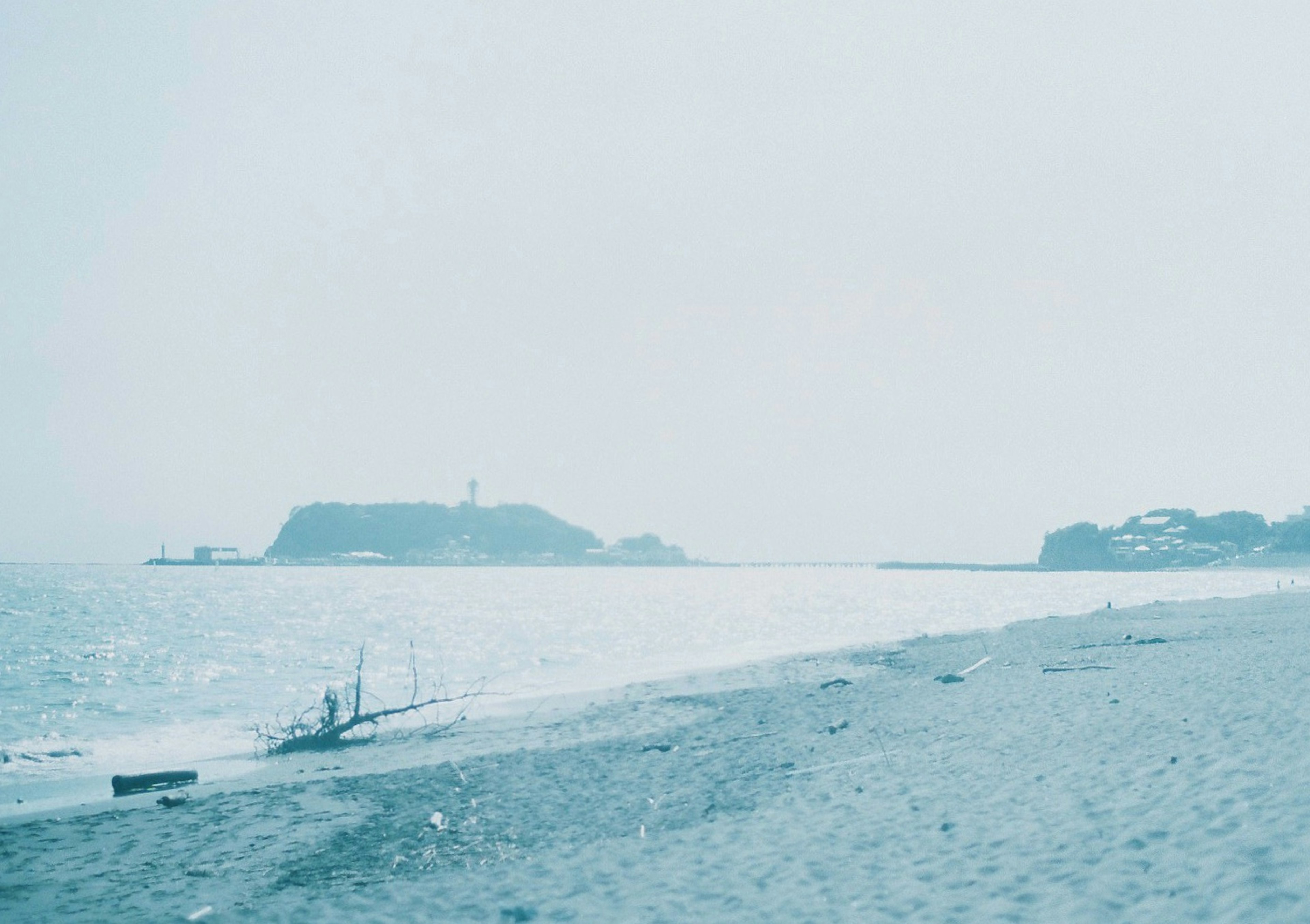 青い海と静かなビーチの風景 島と灯台が遠くに見える