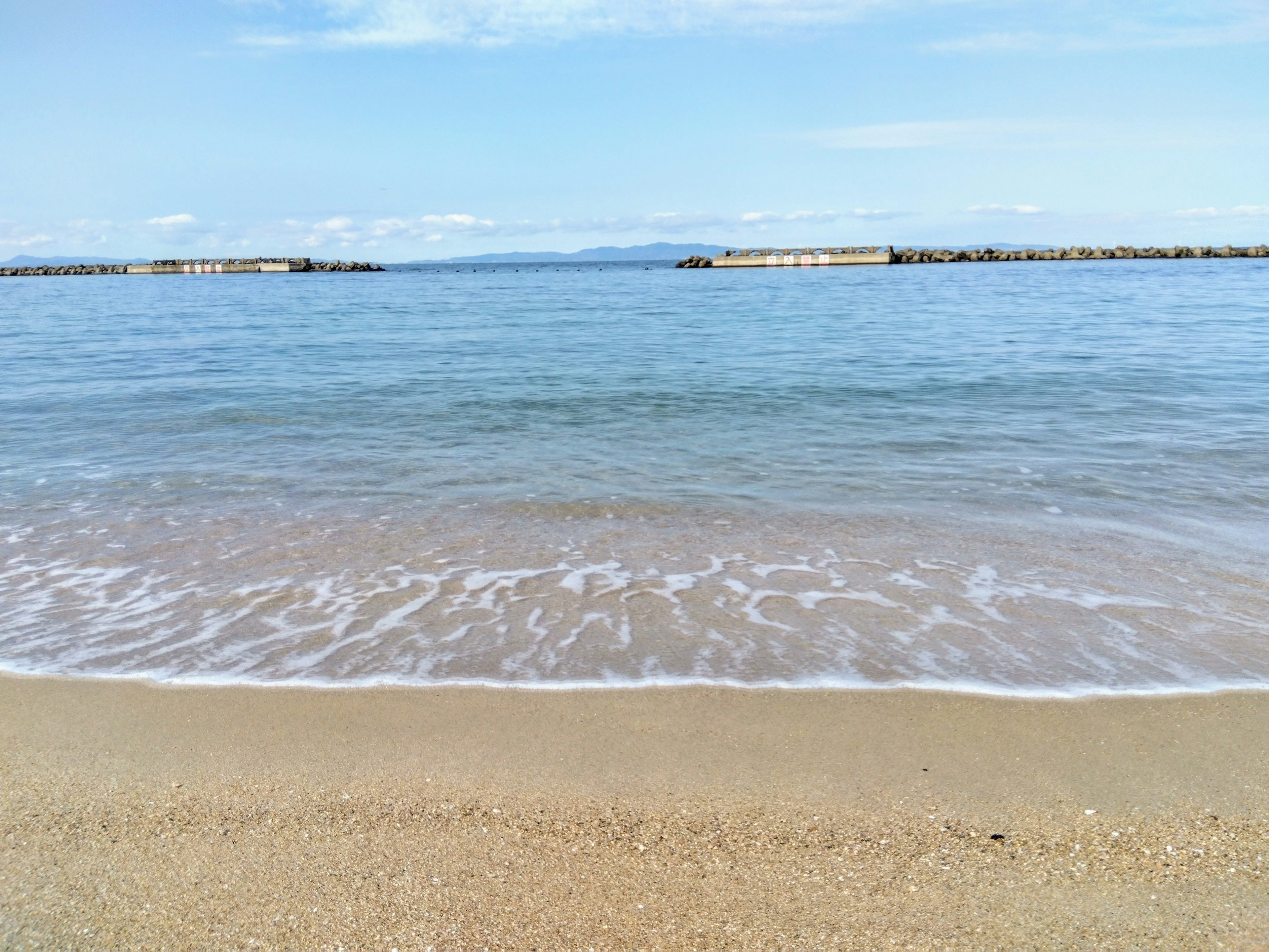 Vista del mare calmo e della spiaggia di sabbia