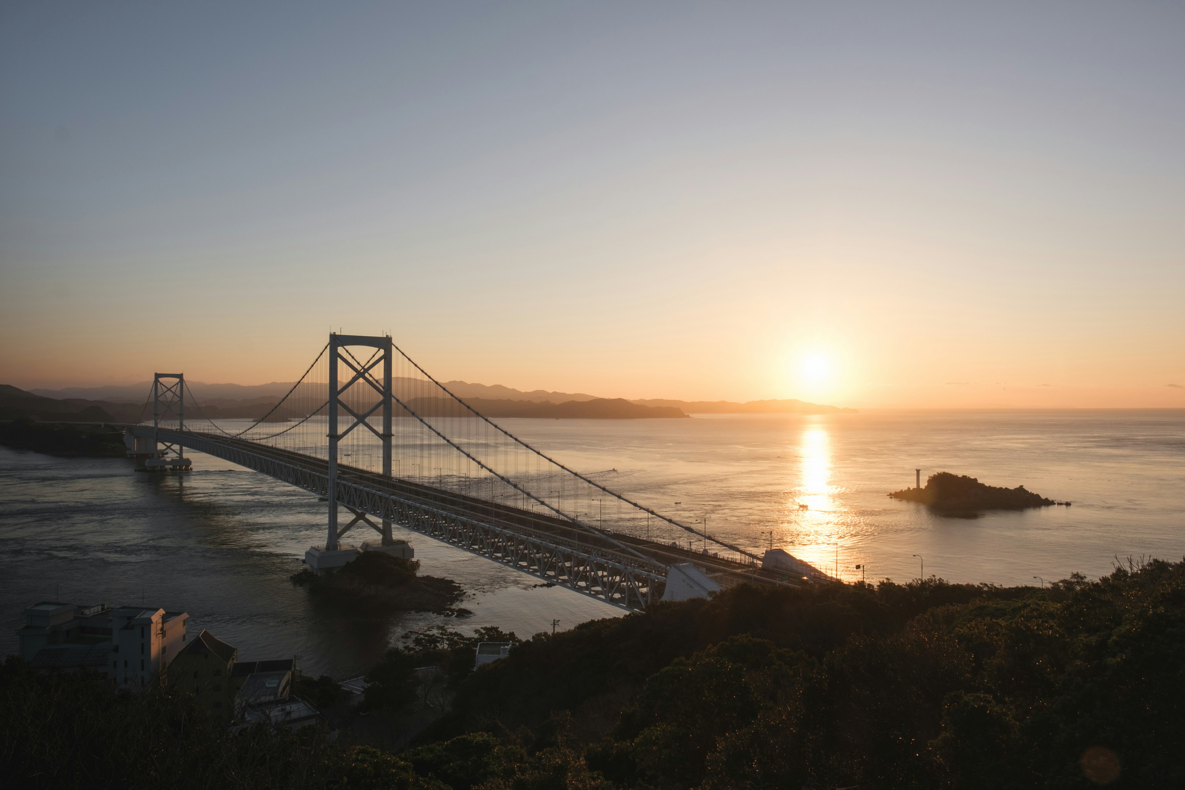 Pont sur l'eau au coucher du soleil avec terre lointaine