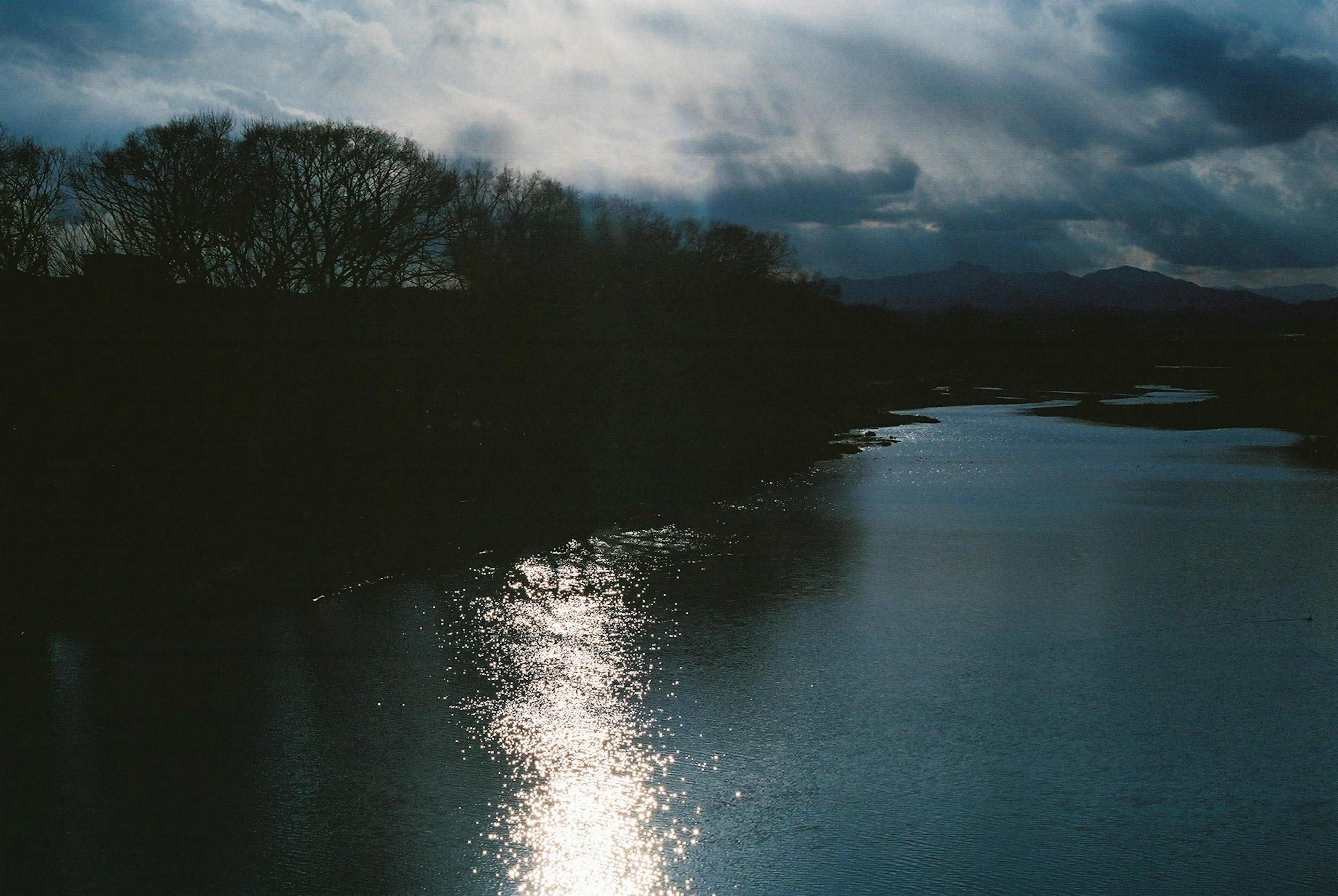 Serene river reflecting a dark sky silhouette