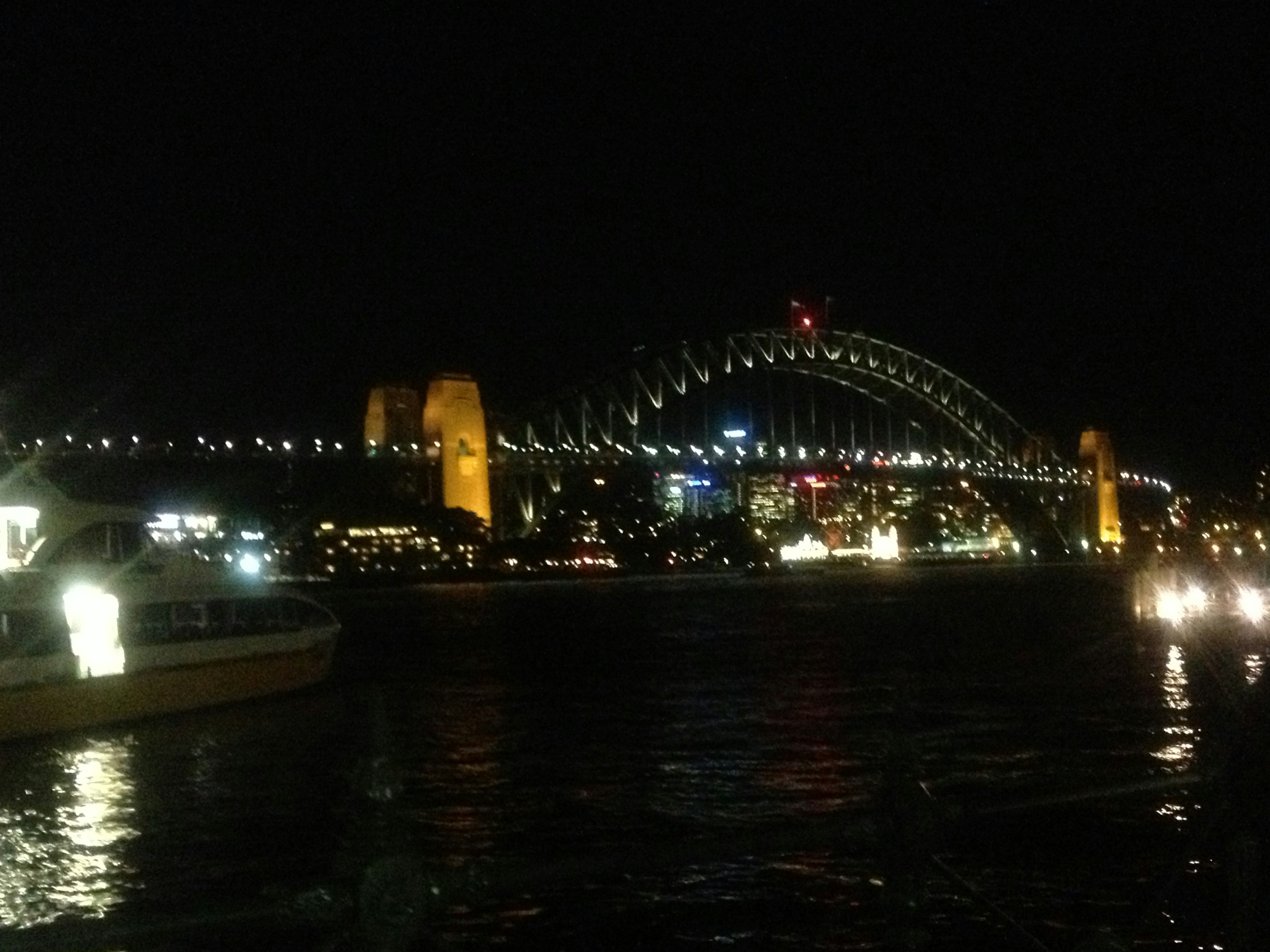 Jembatan Pelabuhan Sydney yang diterangi di malam hari dengan lampu kota