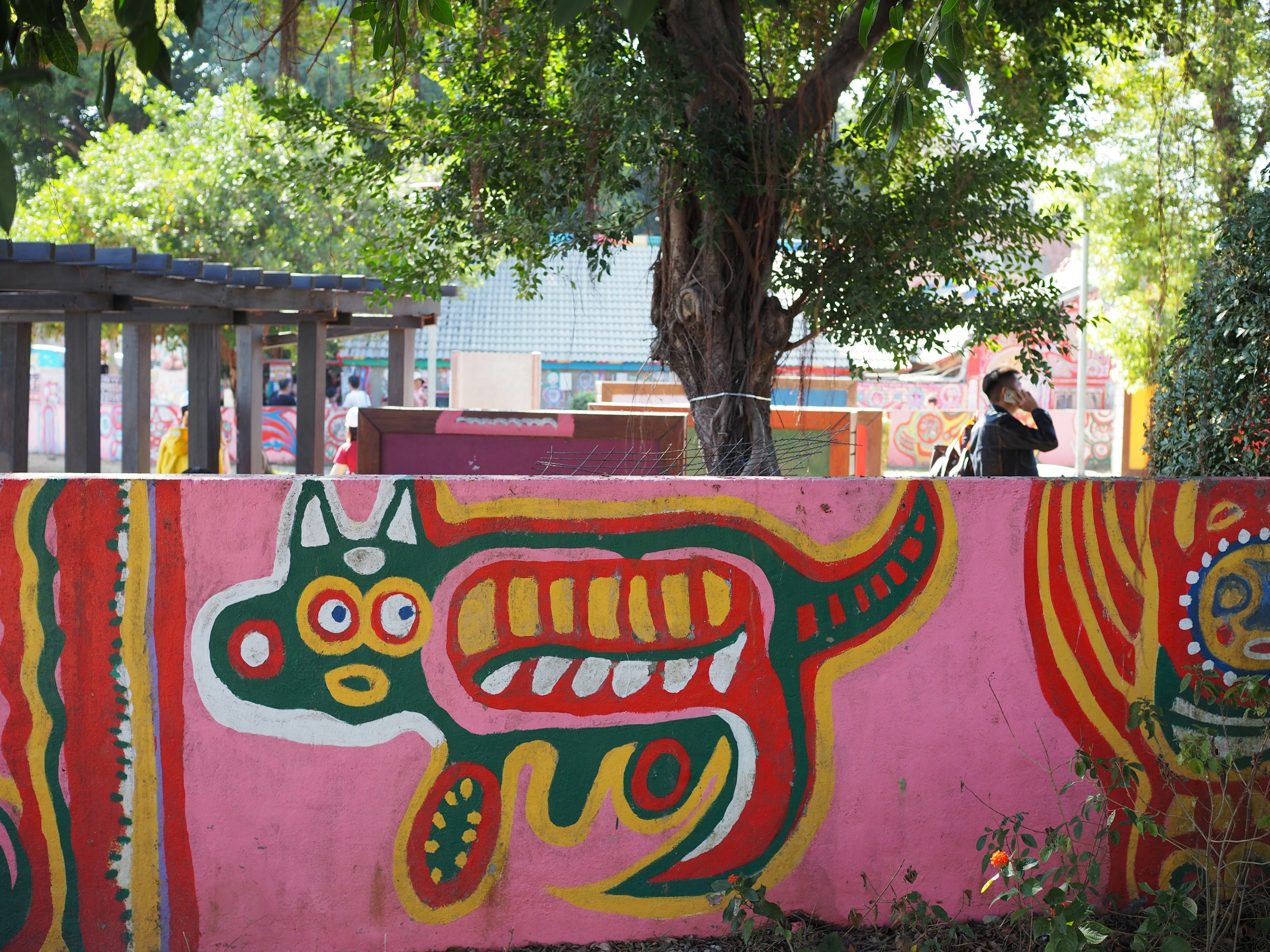 Mural colorido en una pared rosa con un diseño de animal estilizado