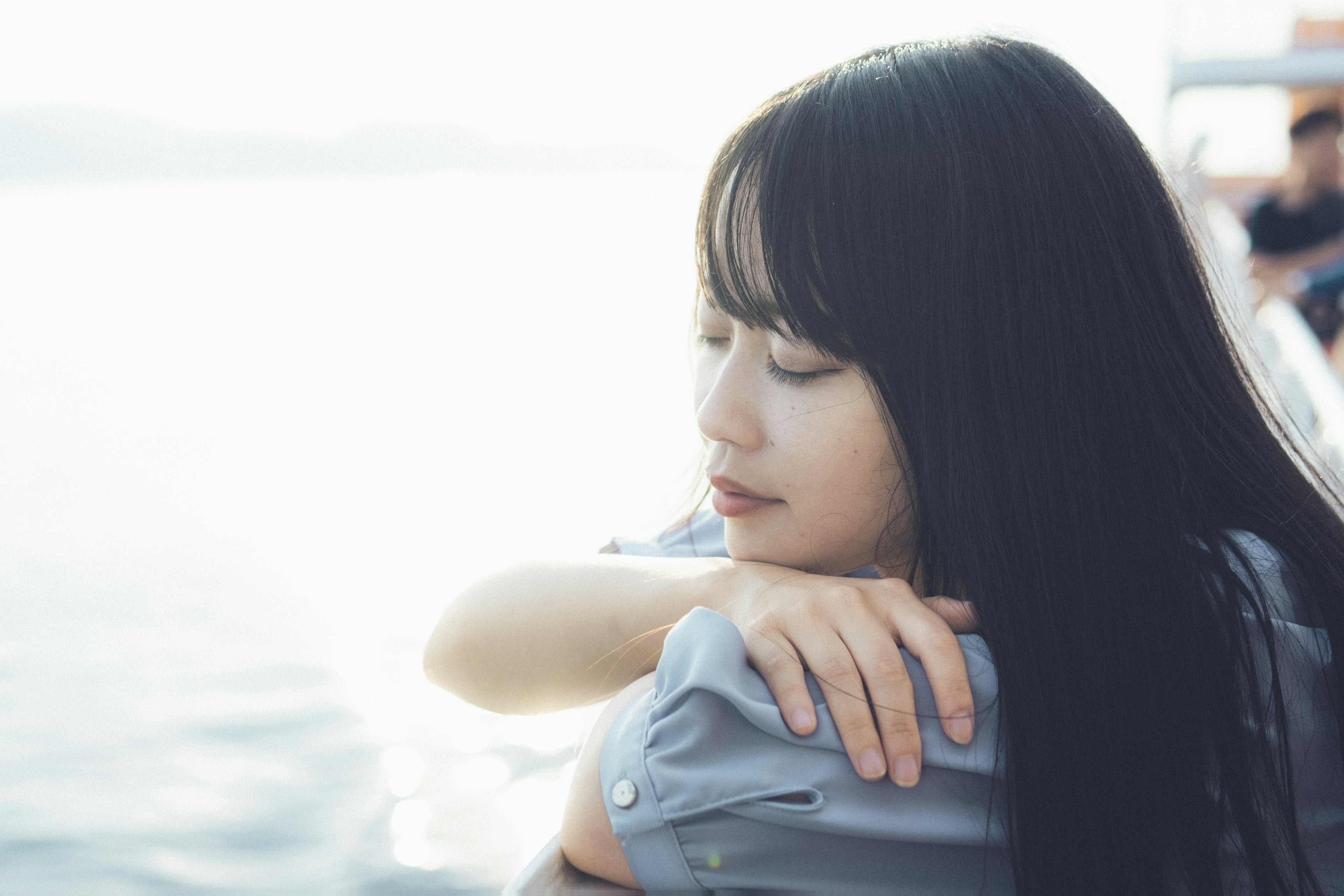 Profil latéral d'une femme avec de longs cheveux sur fond de surface d'eau calme