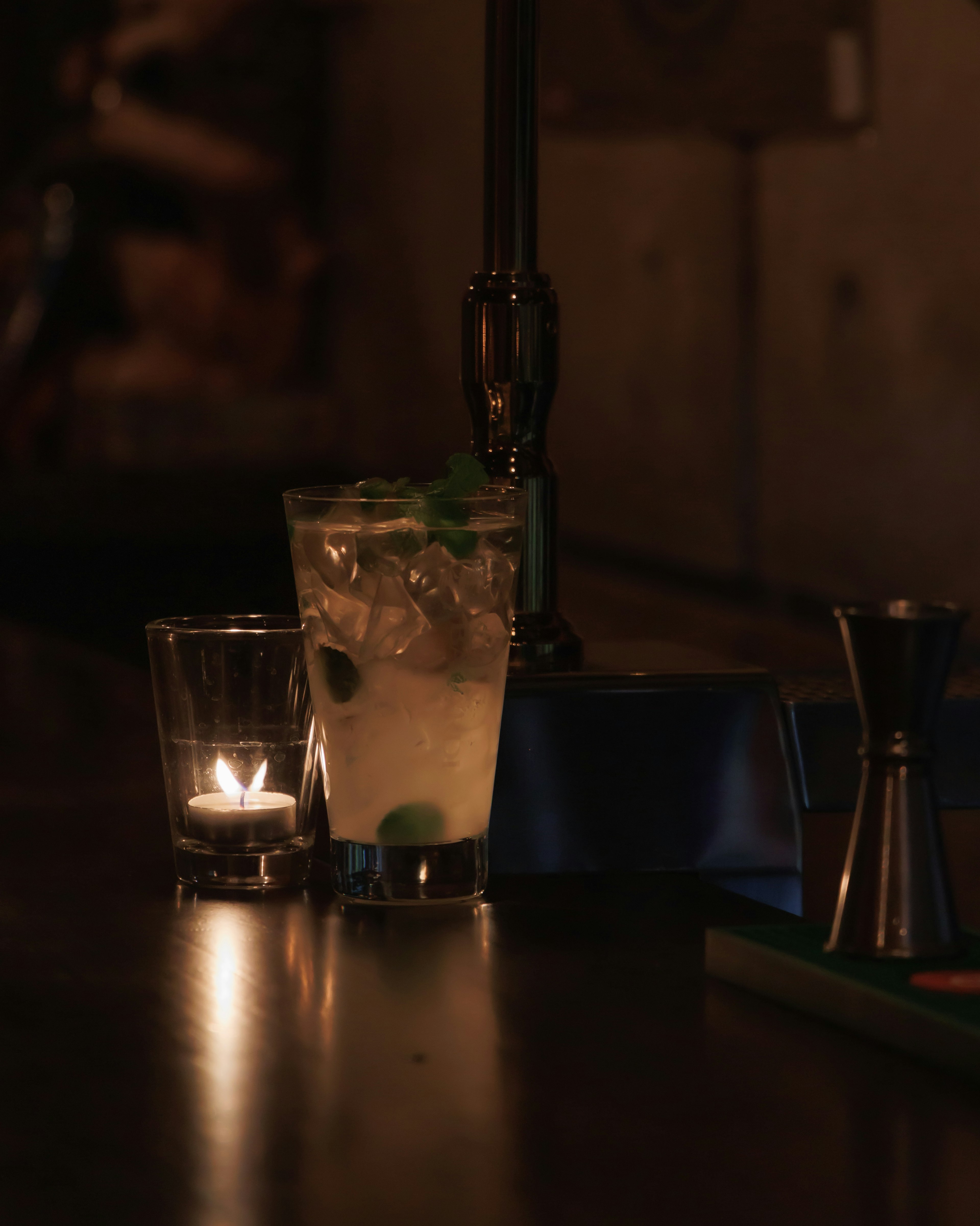 Cocktail và nến trên quầy bar trong không gian ánh sáng mờ