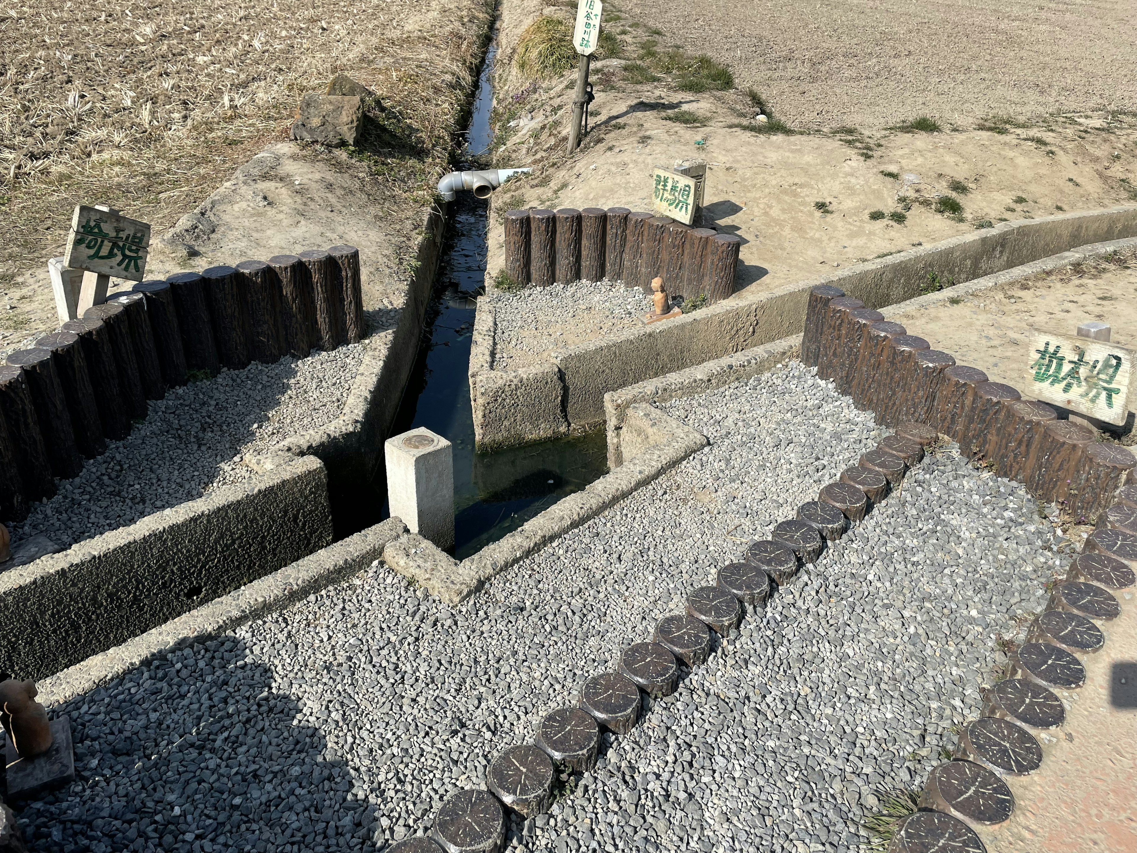 Structures circulaires en pierre sur un sol sec avec un étroit canal d'eau