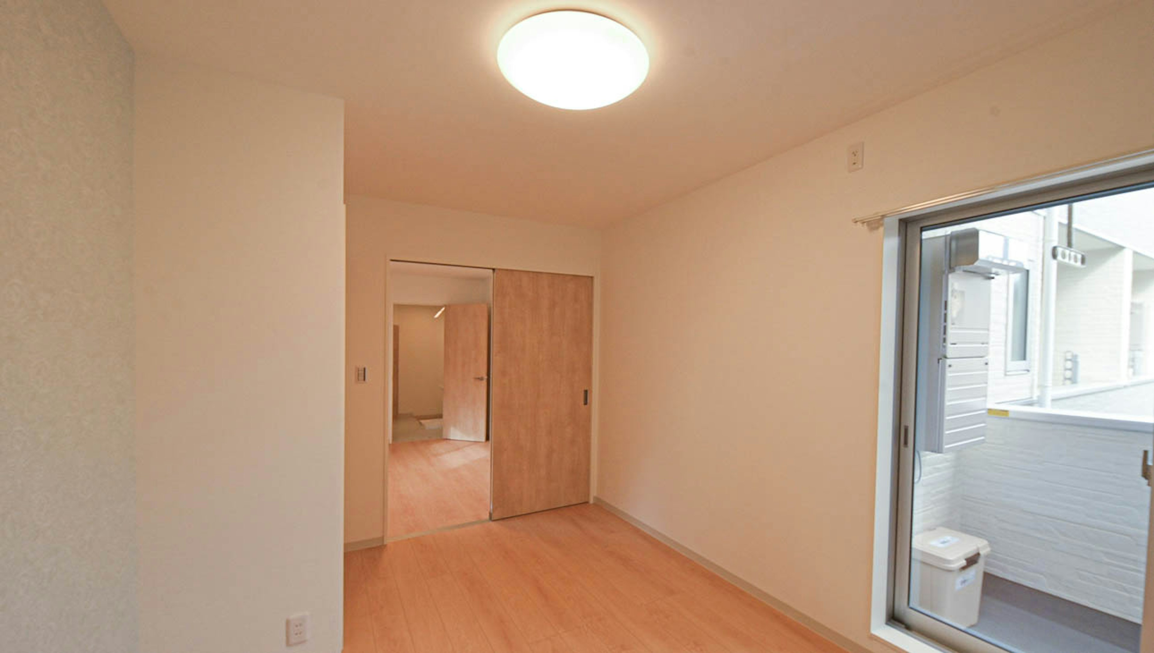 Bright interior view with wooden door, natural light from window, simple design