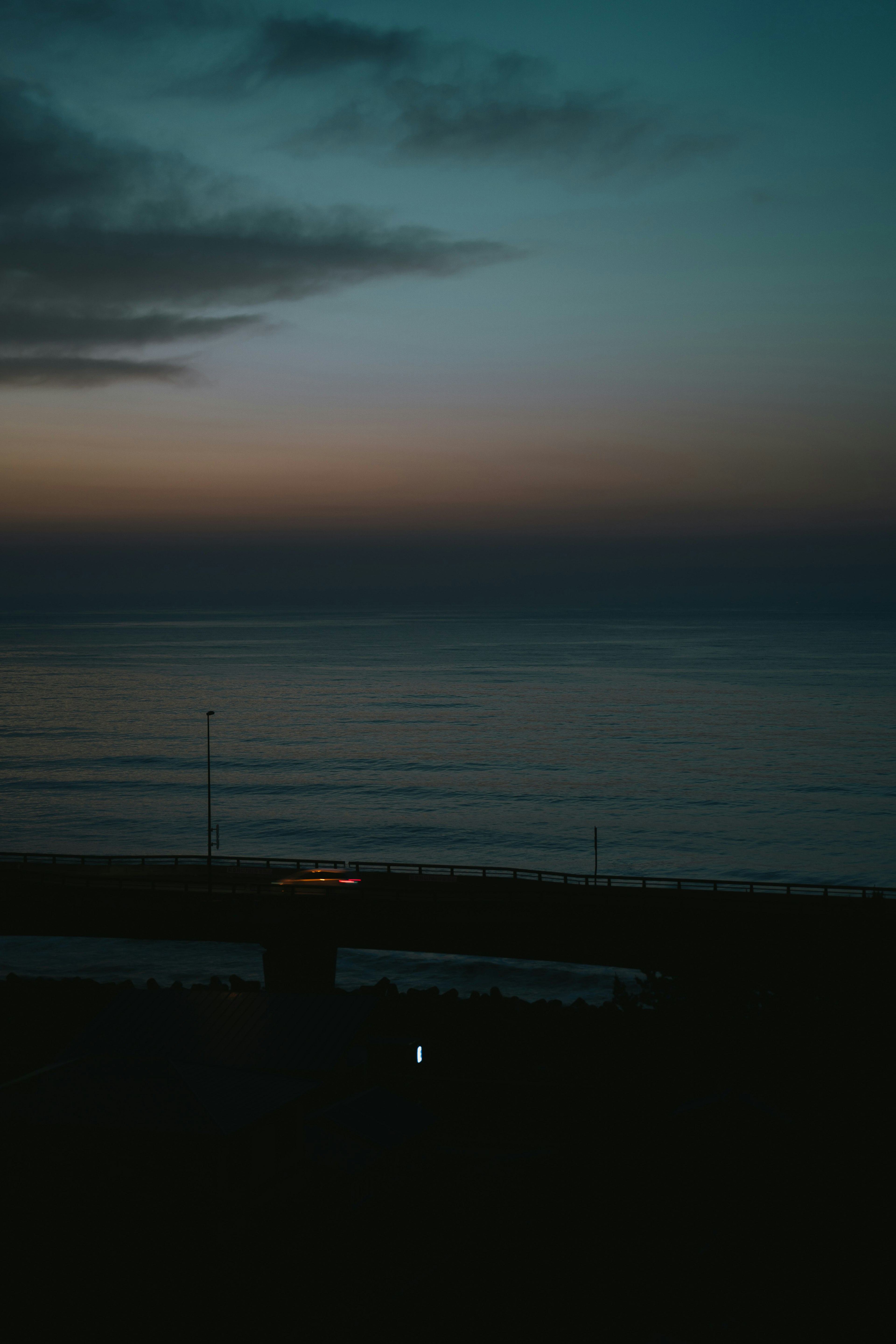 静かな海の夕暮れの風景　穏やかな水面と淡い色合いの空