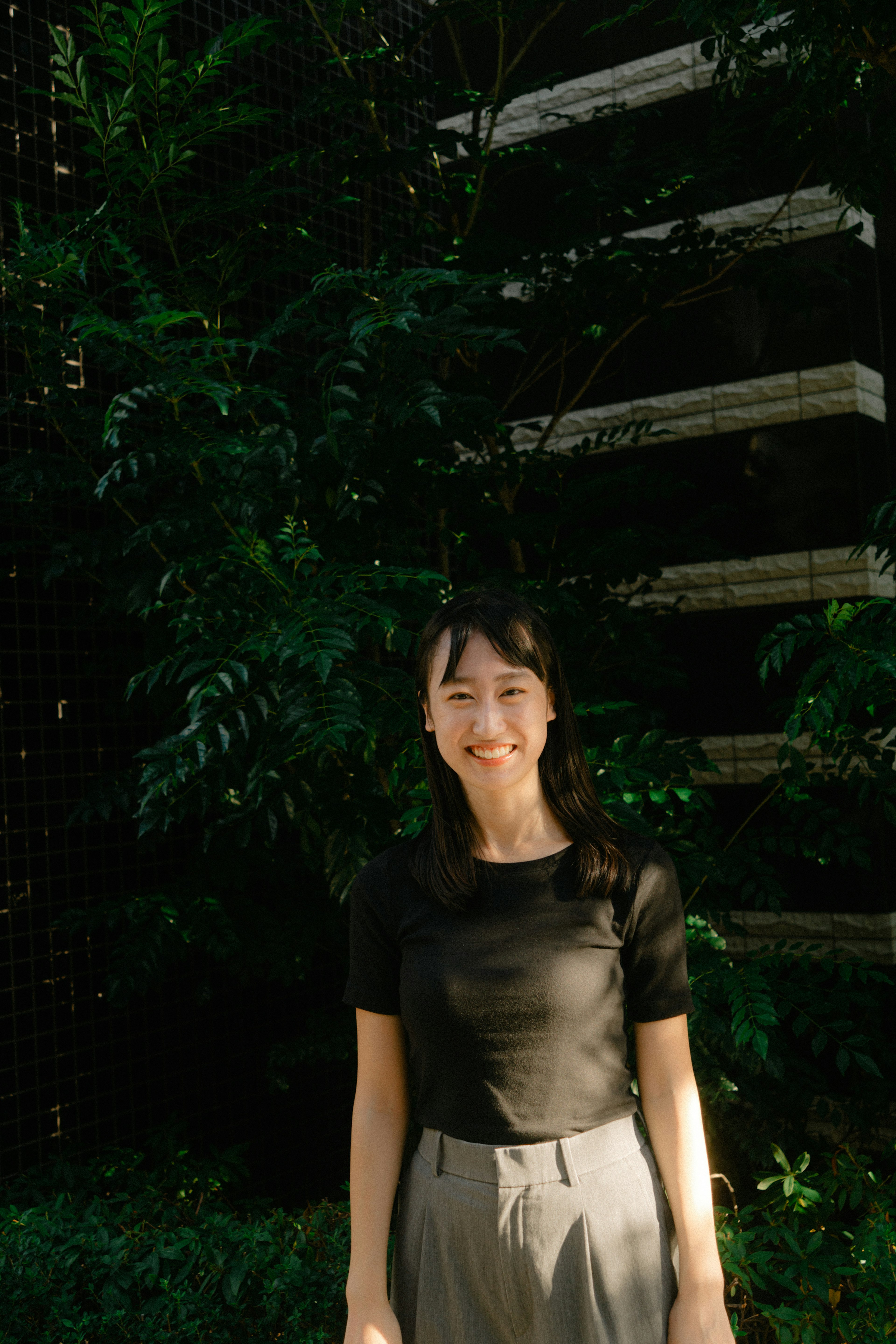 Portrait of a smiling woman standing in front of a green background