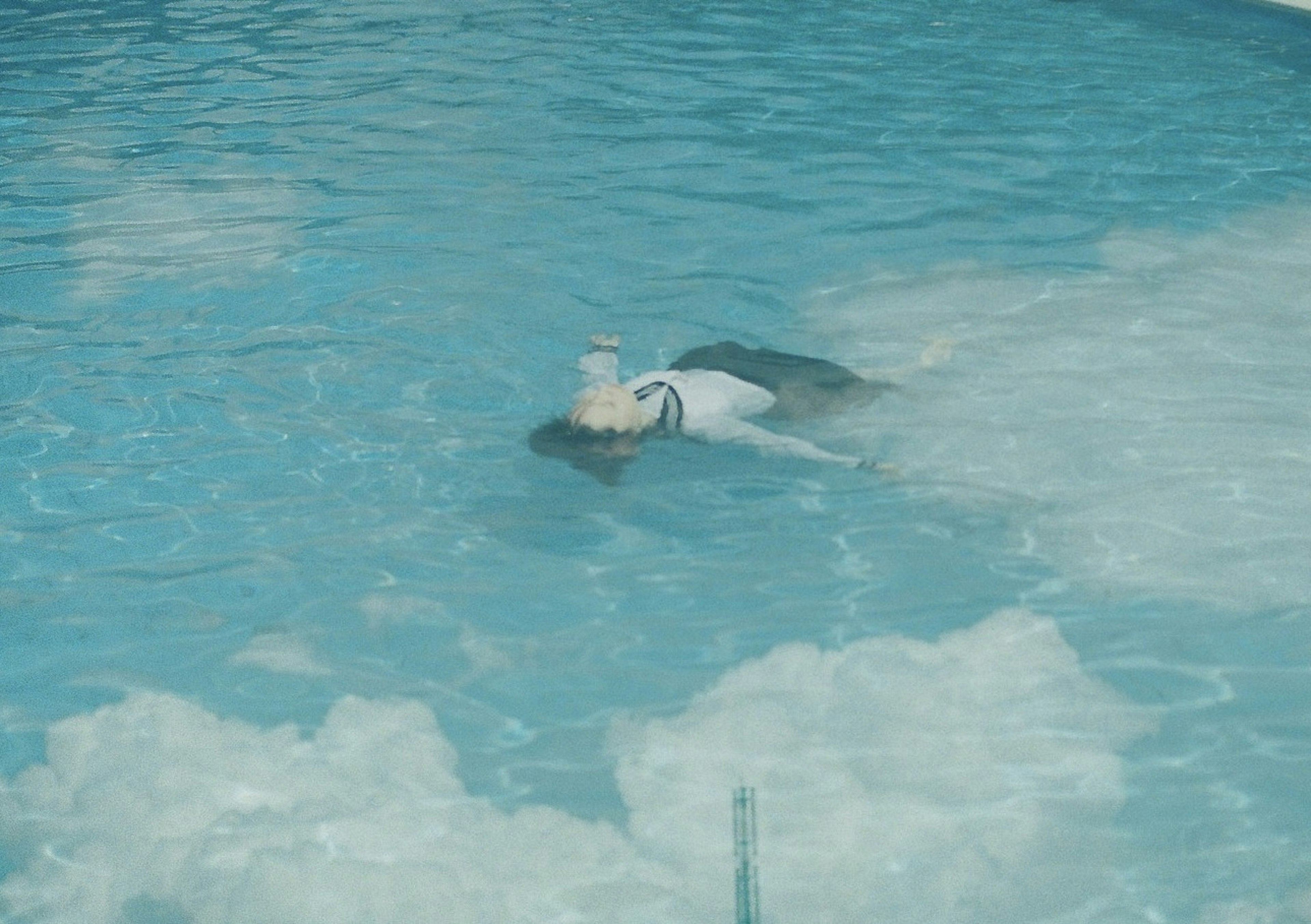 プールで浮いている人の姿と水の色合い