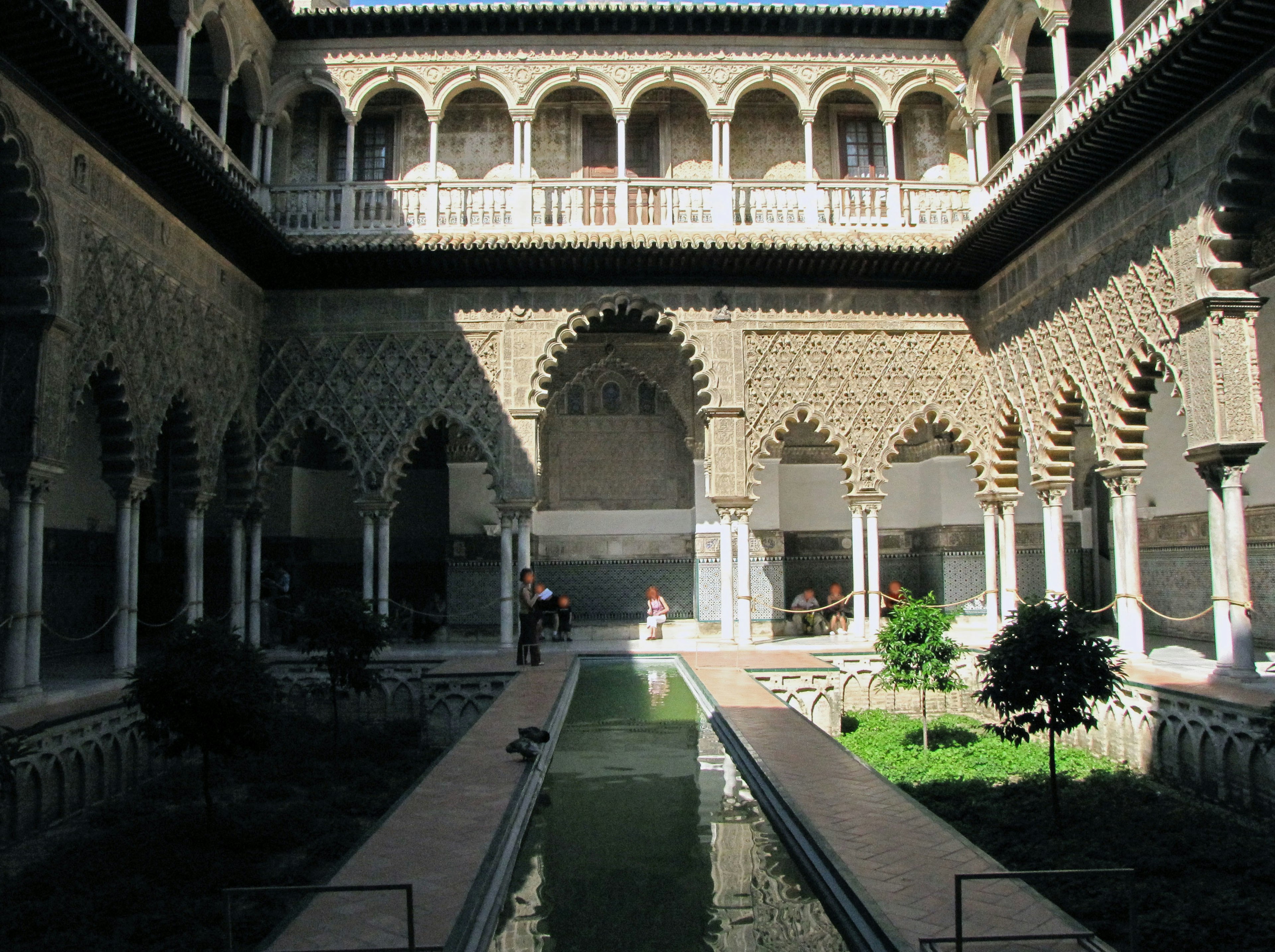 Beau patio avec des motifs arabesques complexes et une fontaine entourée de verdure