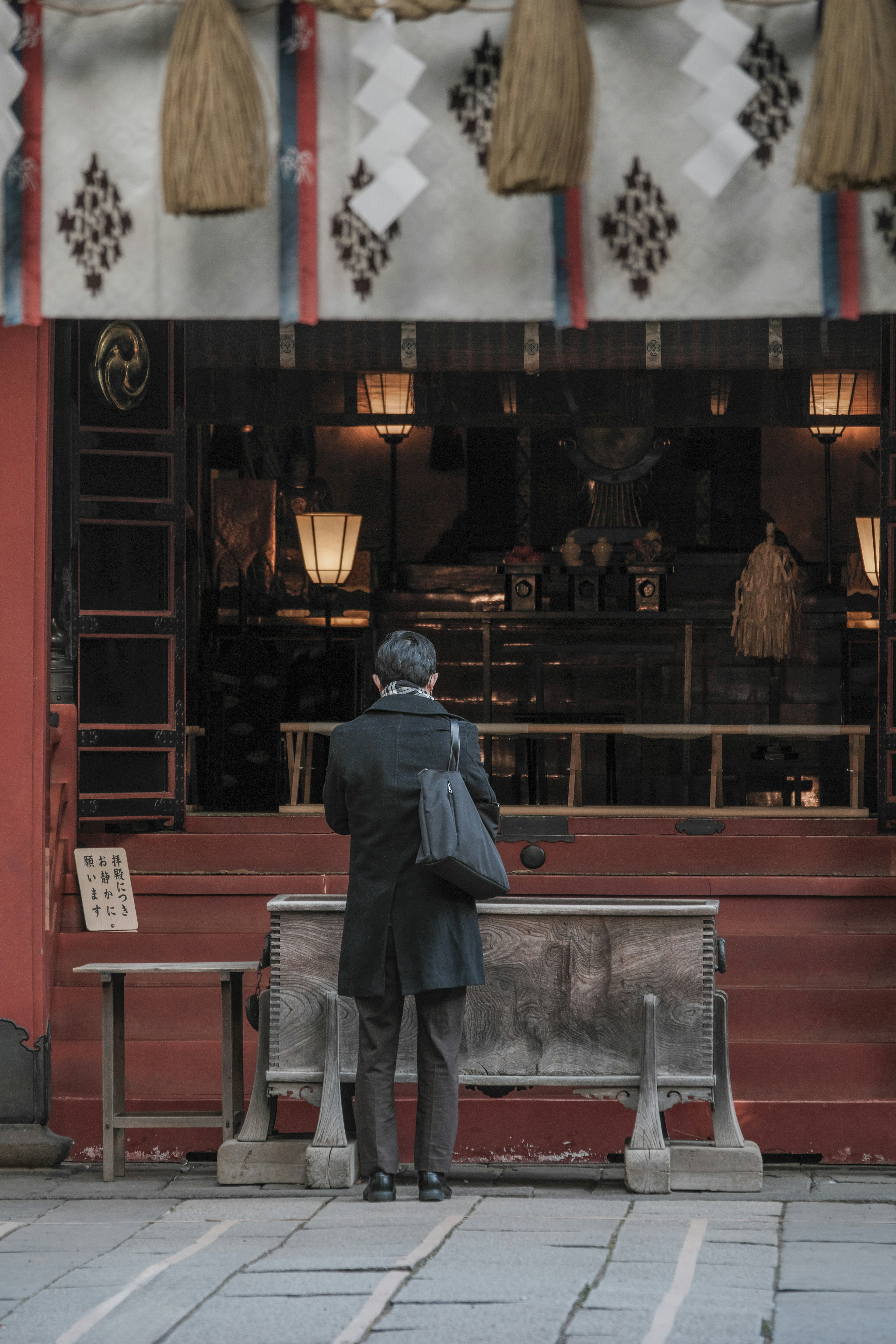 A man standing in front of a shop with visible lamps and decorations inside