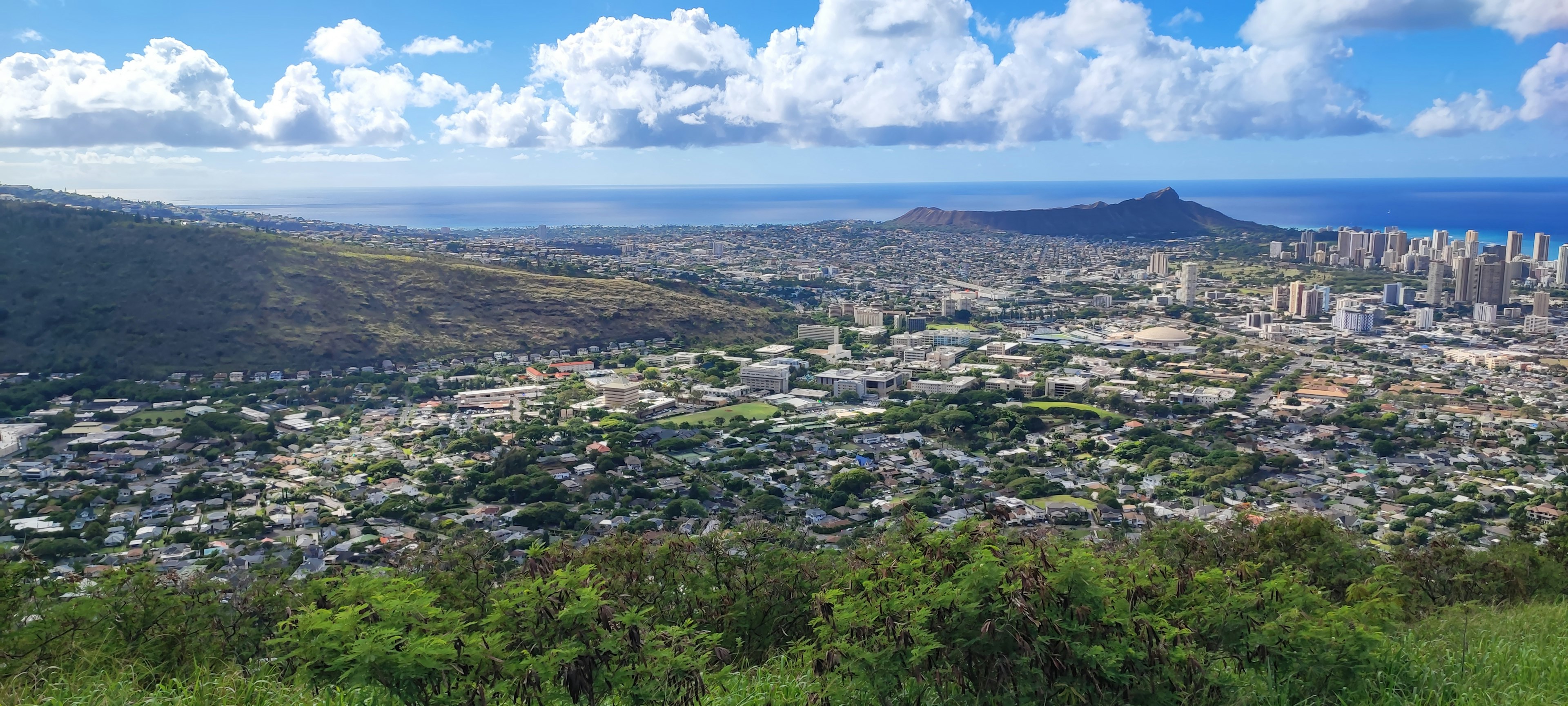 Panoramablick auf Honolulu mit blauem Himmel grünen Hügeln und Ozeanszenerie