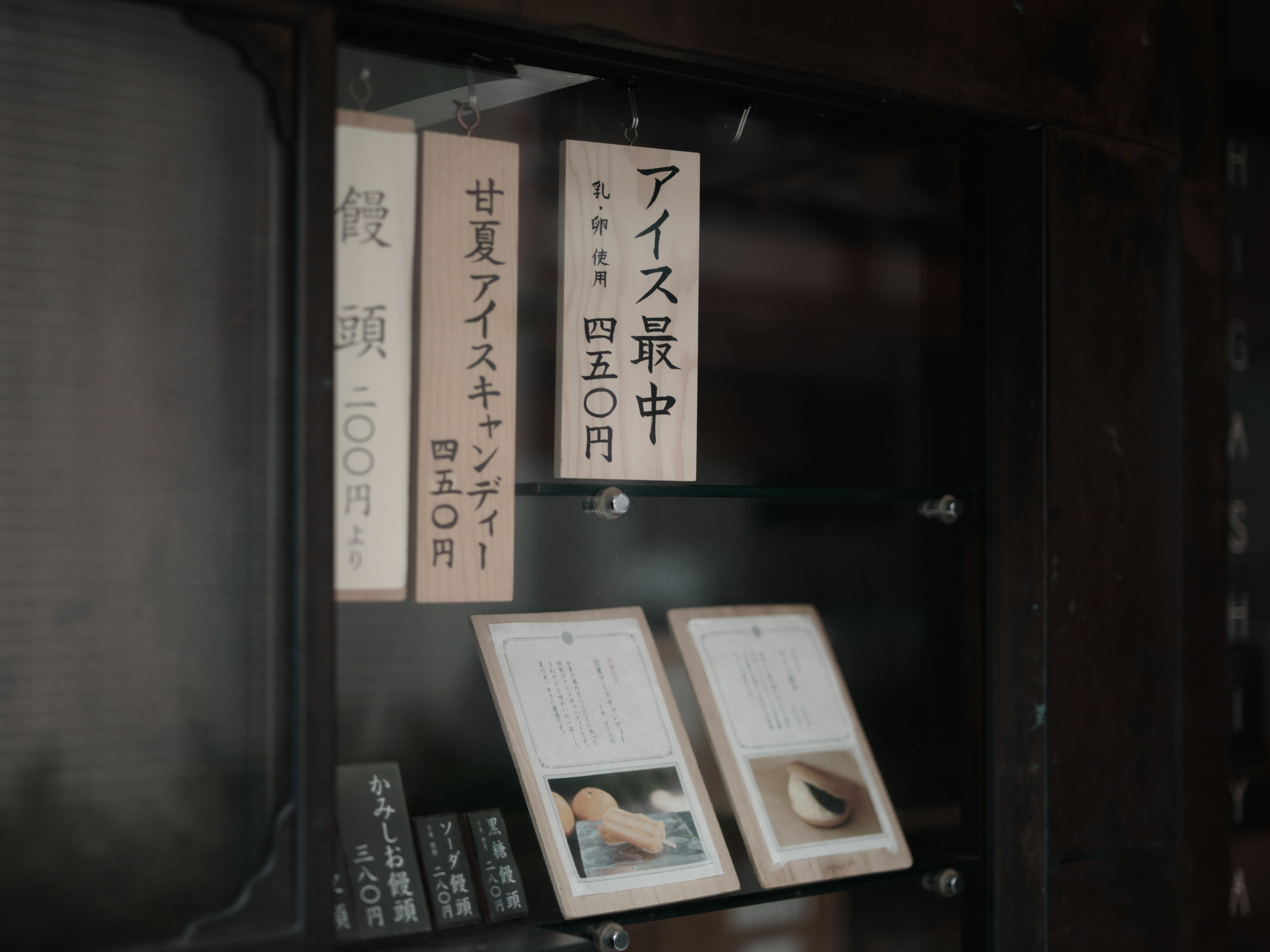 Photo d'une vitrine en verre présentant des menus et des produits à l'intérieur d'un magasin