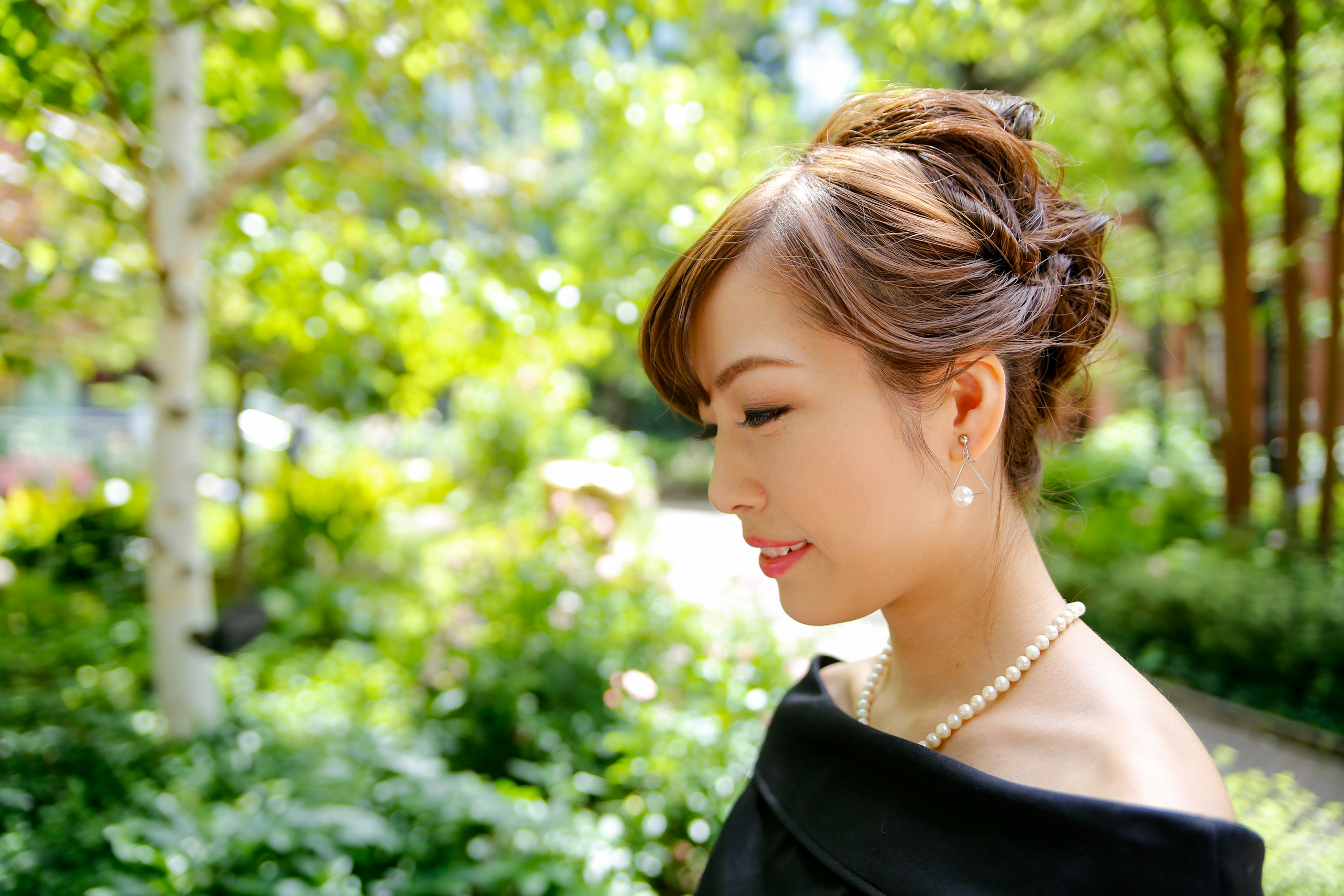 Portrait of a woman smiling sideways in a lush green background