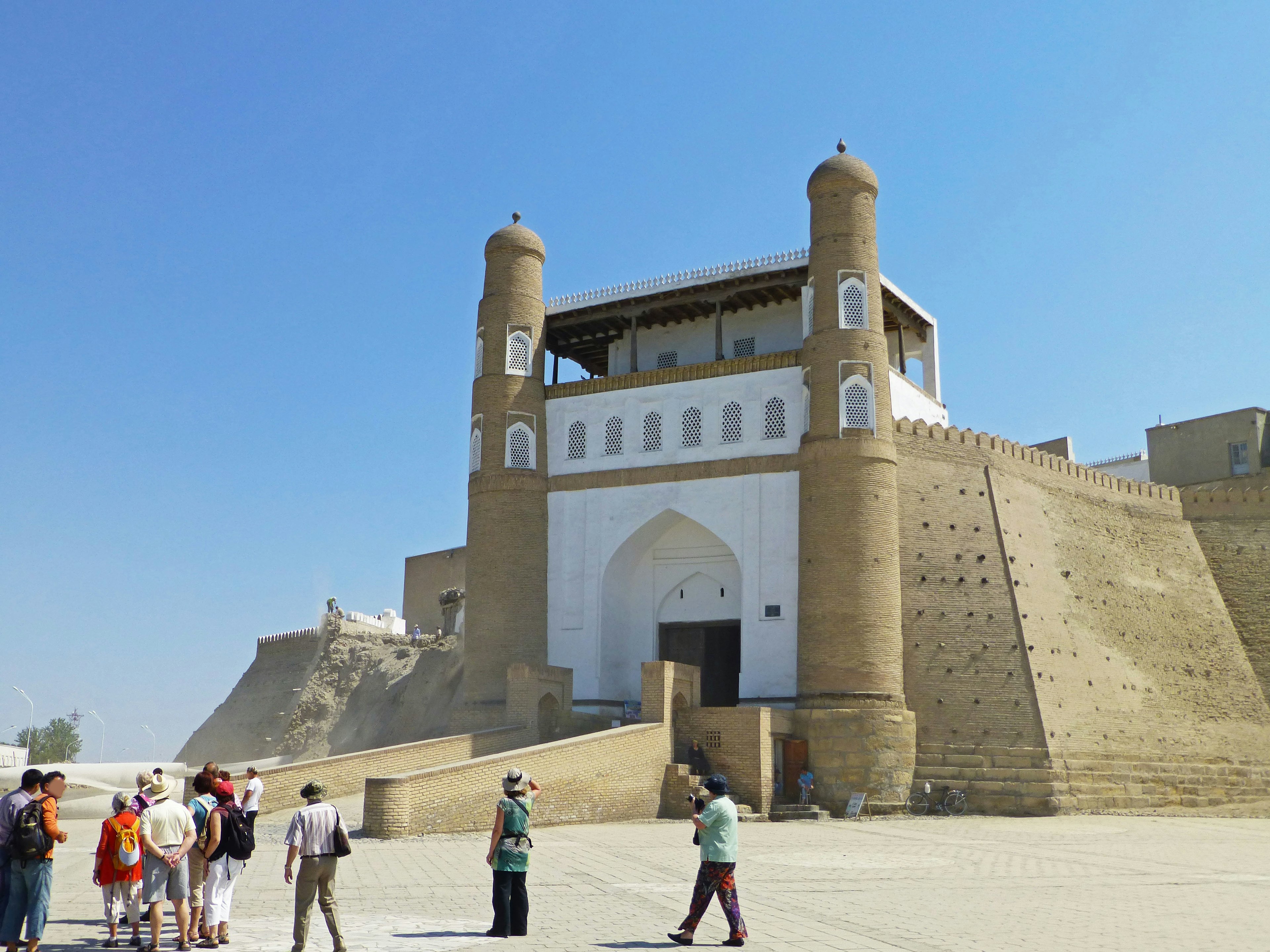 A large fortress gate with tourists gathered around it