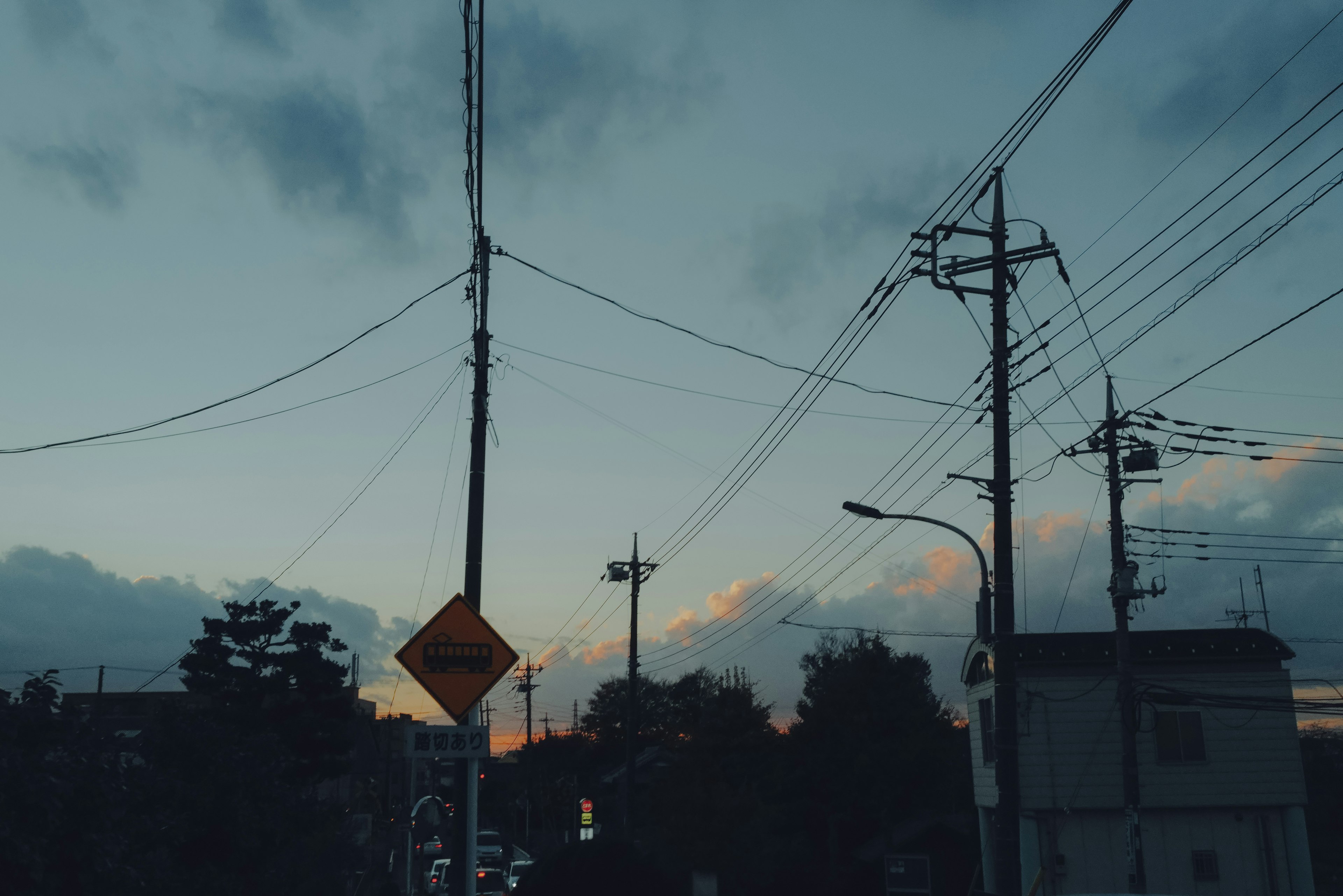 Paesaggio urbano al crepuscolo con linee elettriche e nuvole