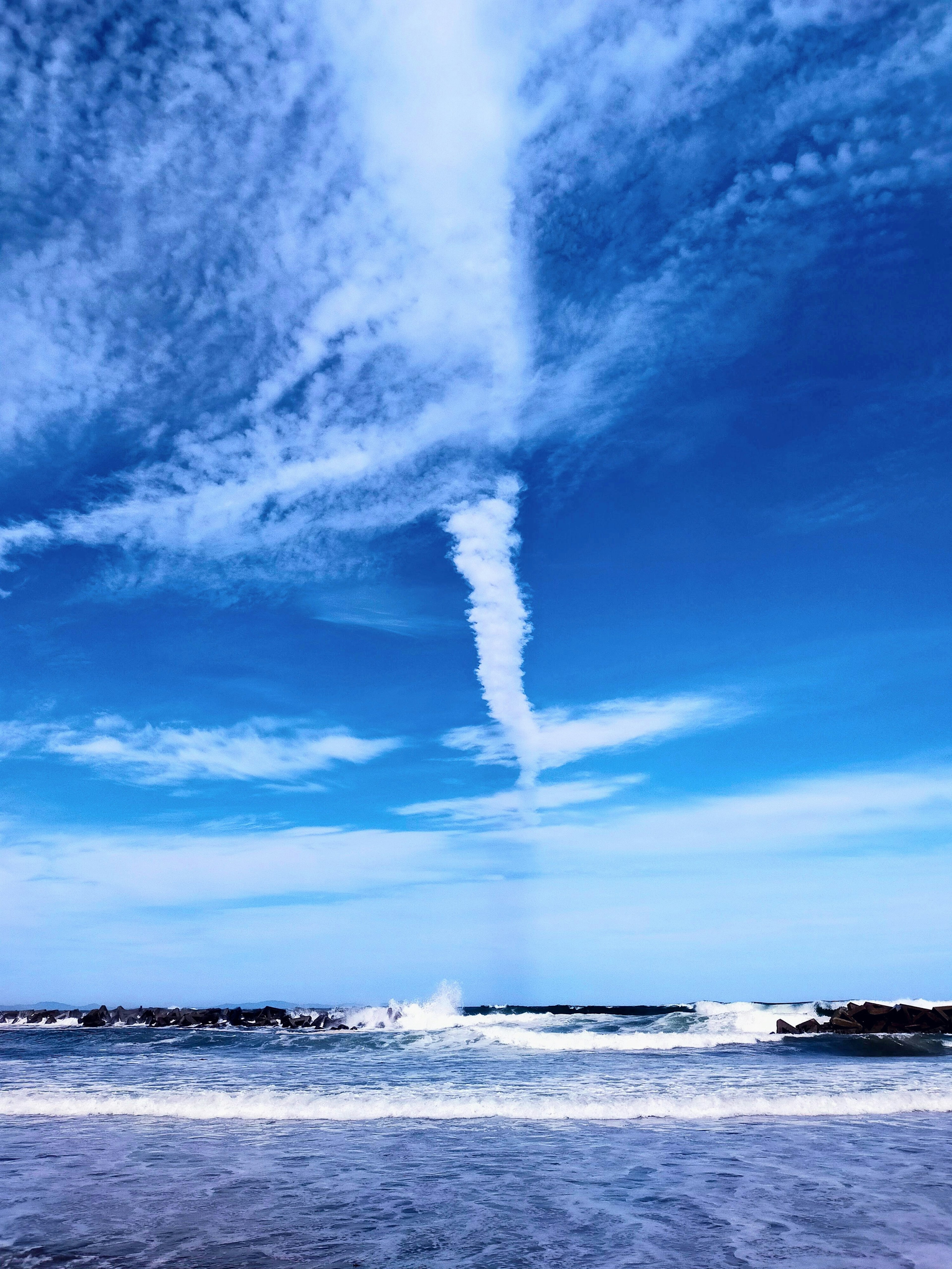 Une vue pittoresque du ciel bleu avec des nuages et des vagues océaniques