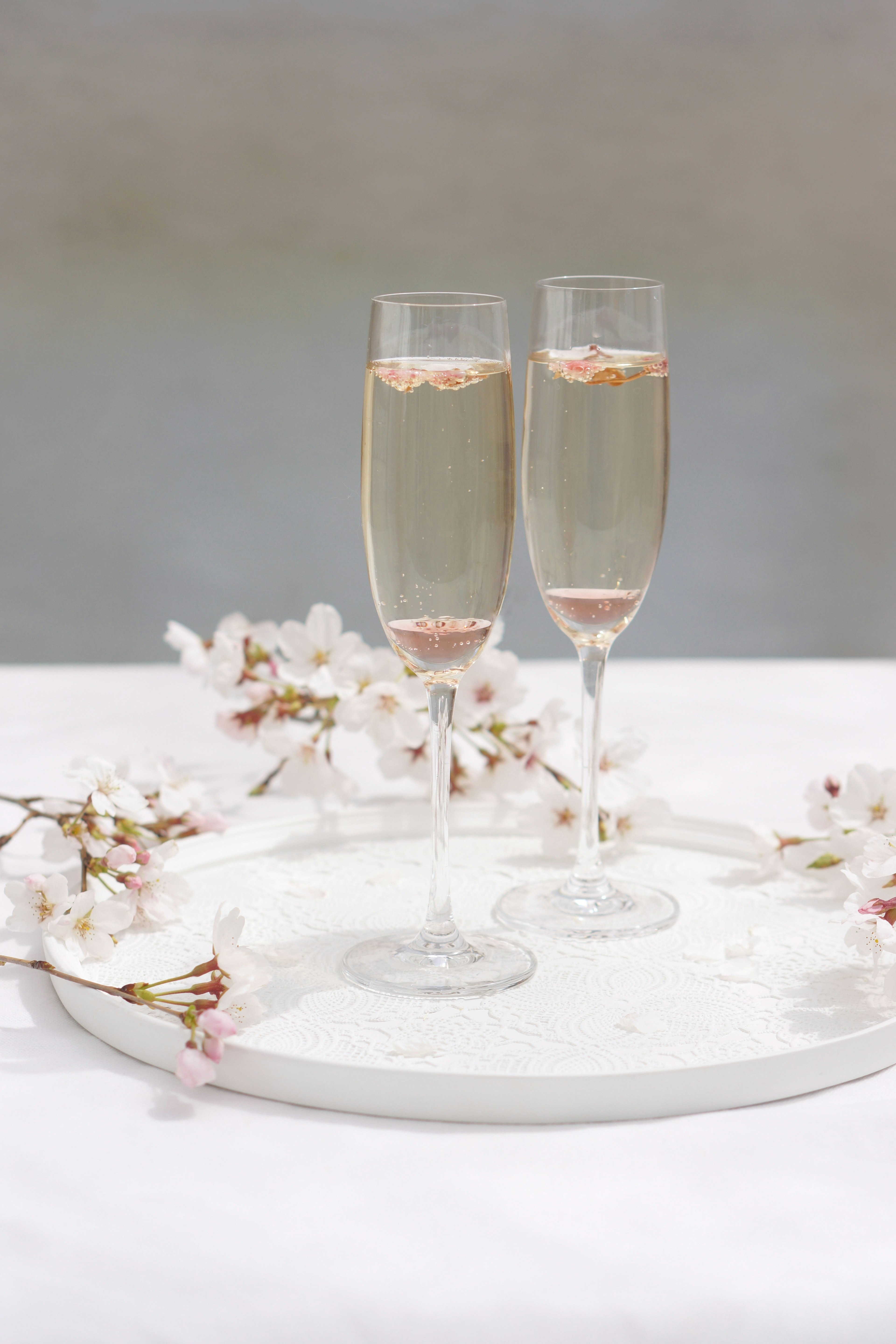 Elegante apparecchiatura da tavola con flûti di champagne e fiori di ciliegio