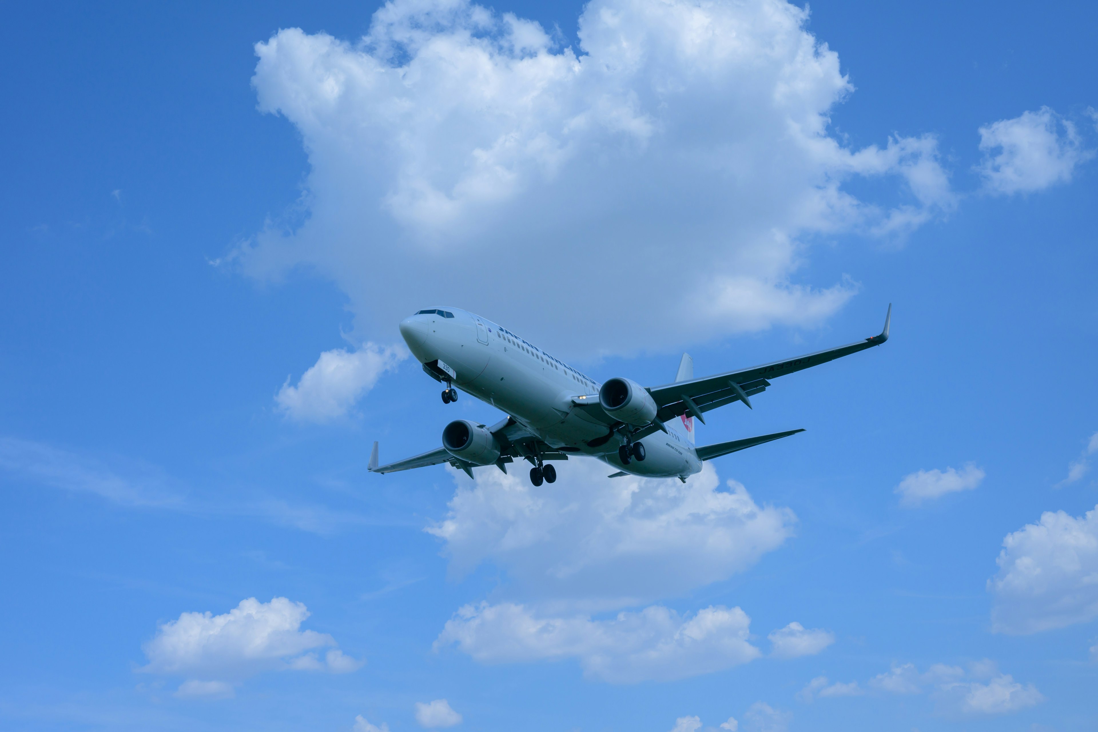 青空を背景に飛行する航空機の画像