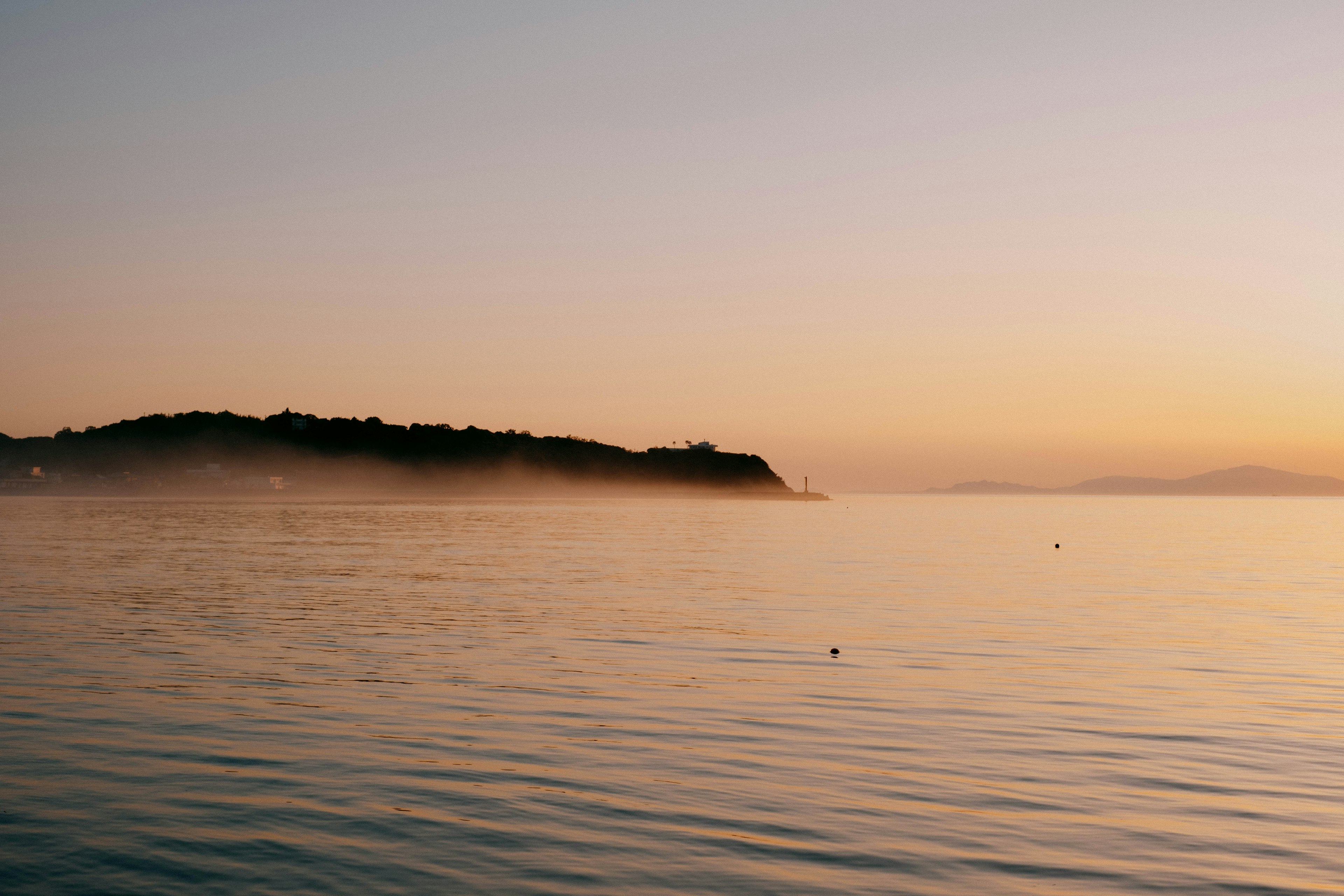 Serene ocean view with mist at sunset