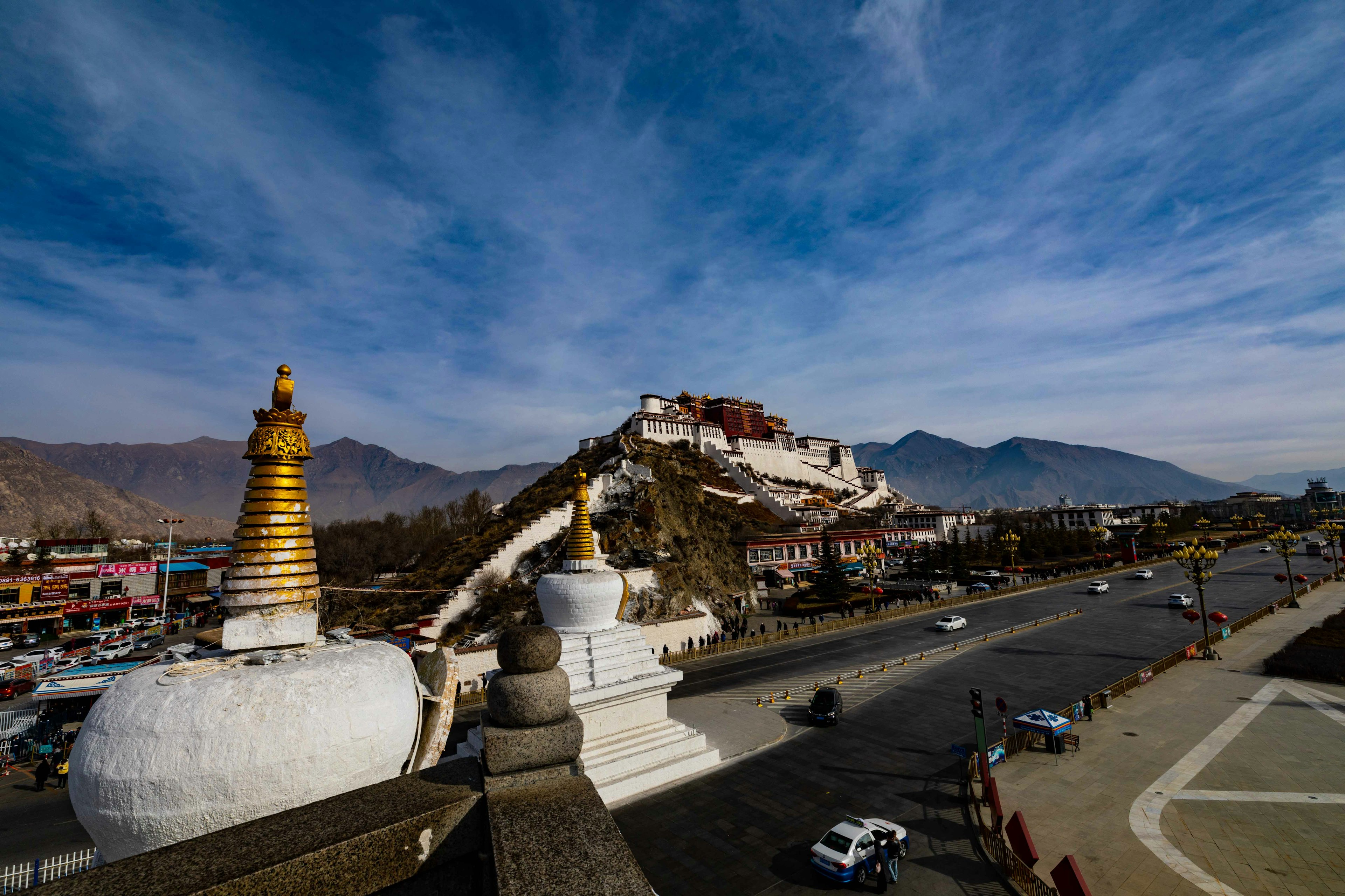 Pemandangan menakjubkan dari Istana Potala di Lhasa dengan langit cerah dan pegunungan di sekitarnya